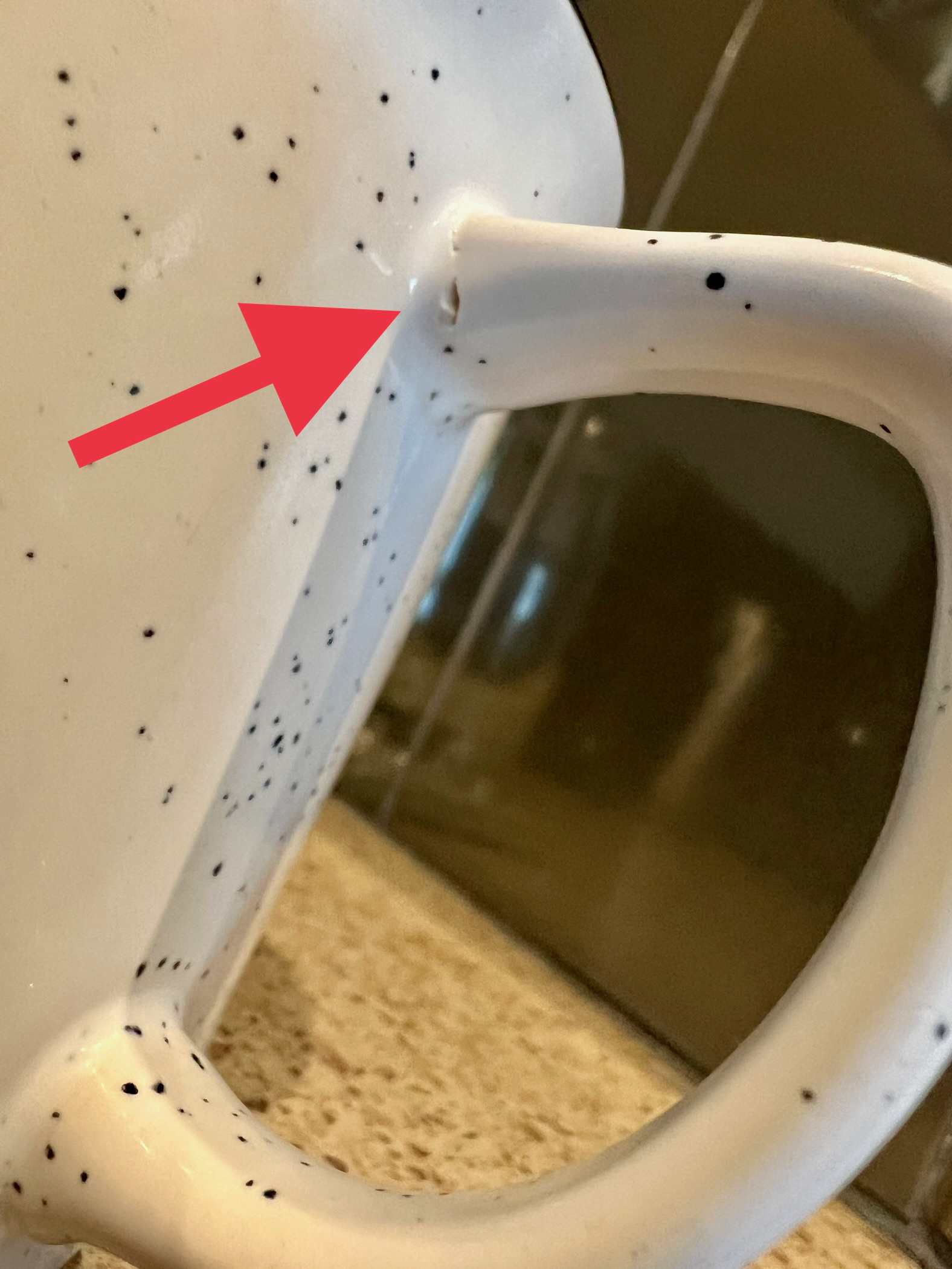 Closeup of Netlify mug’s handle with an arrow pointing to the crack where the handle meets the mug.