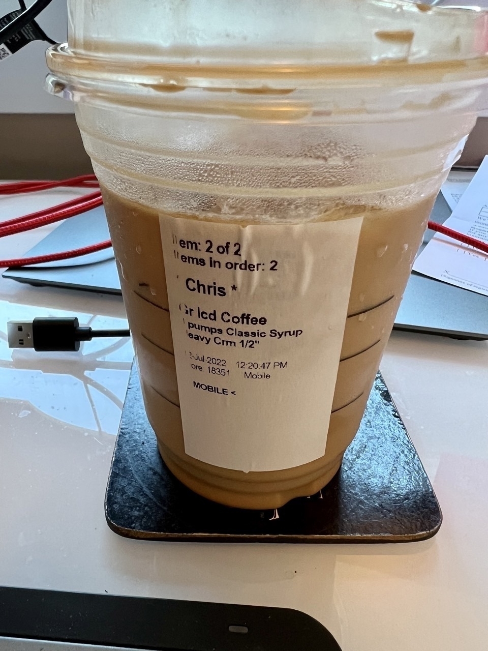 Starbucks iced coffee drink with a sticker on it for *Chris*.