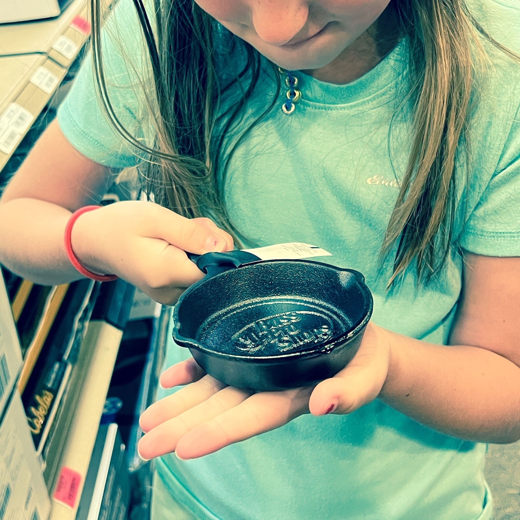 a child holding a skillet pan smallee than her hand 