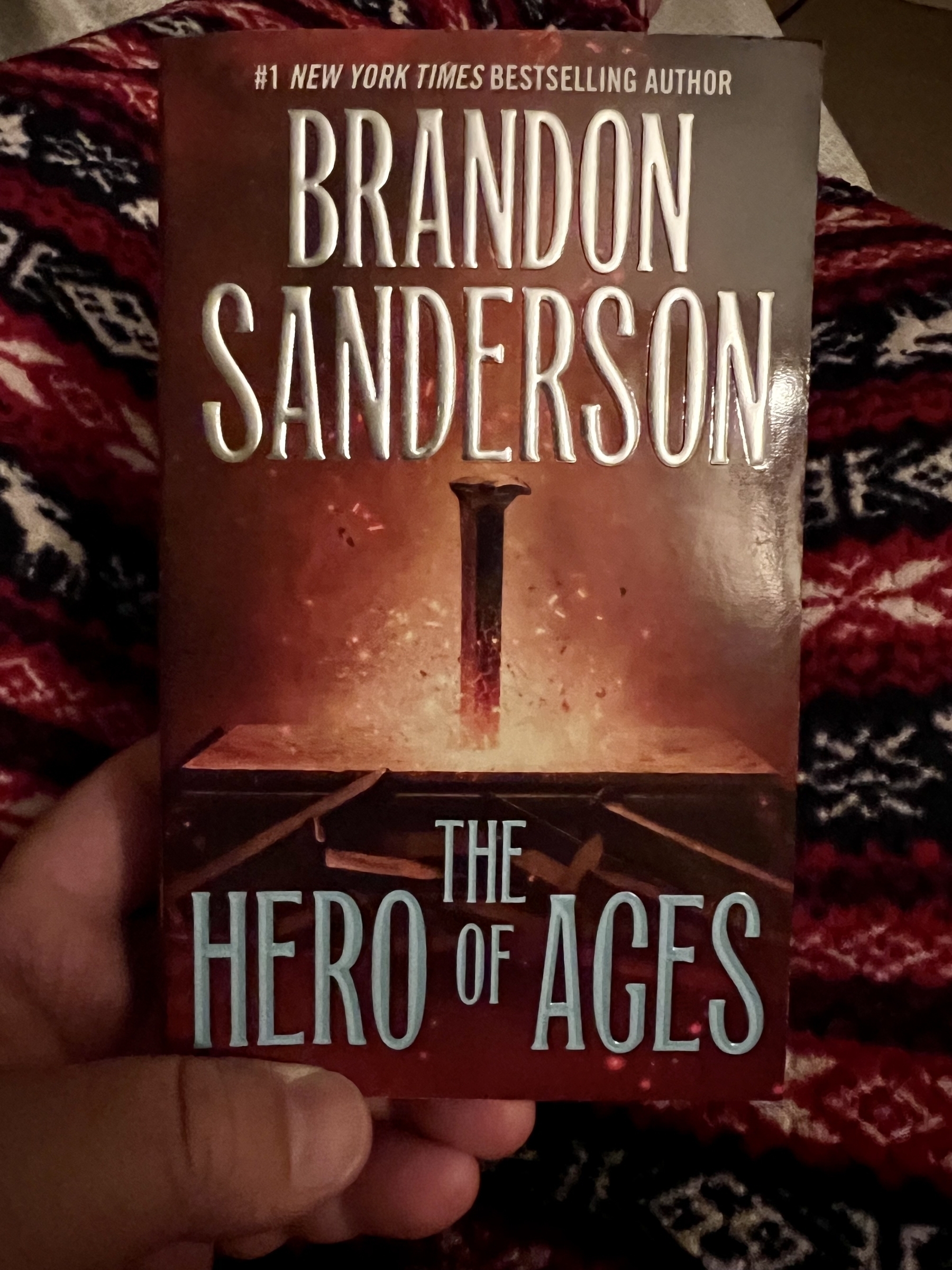 The Hero of Ages by Brandon Sanderson book is pictured in my hand. 