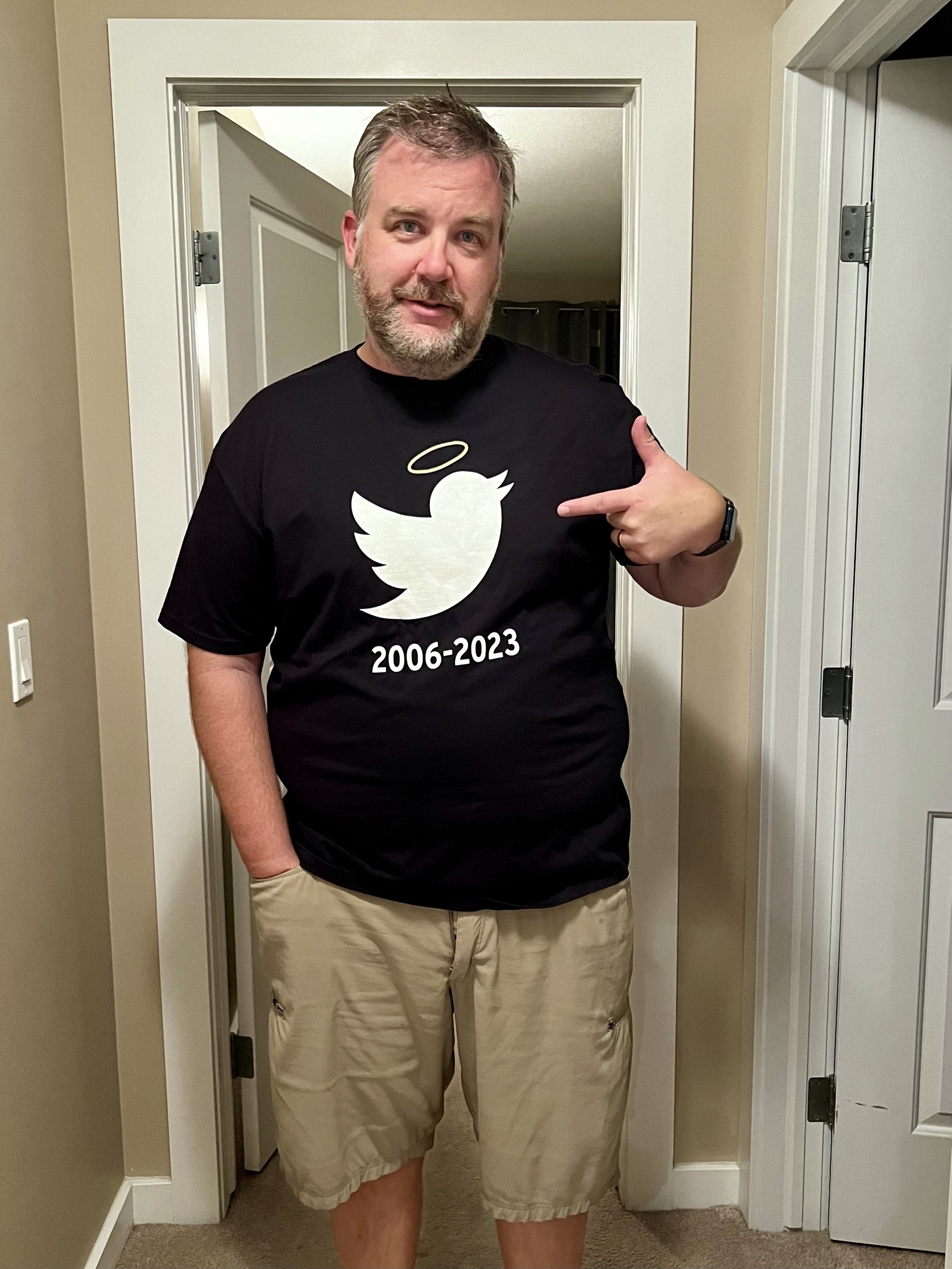 Me wearing a shirt that has the Twitter bird logo with a 2006 - 2023, and a halo over the bird.
