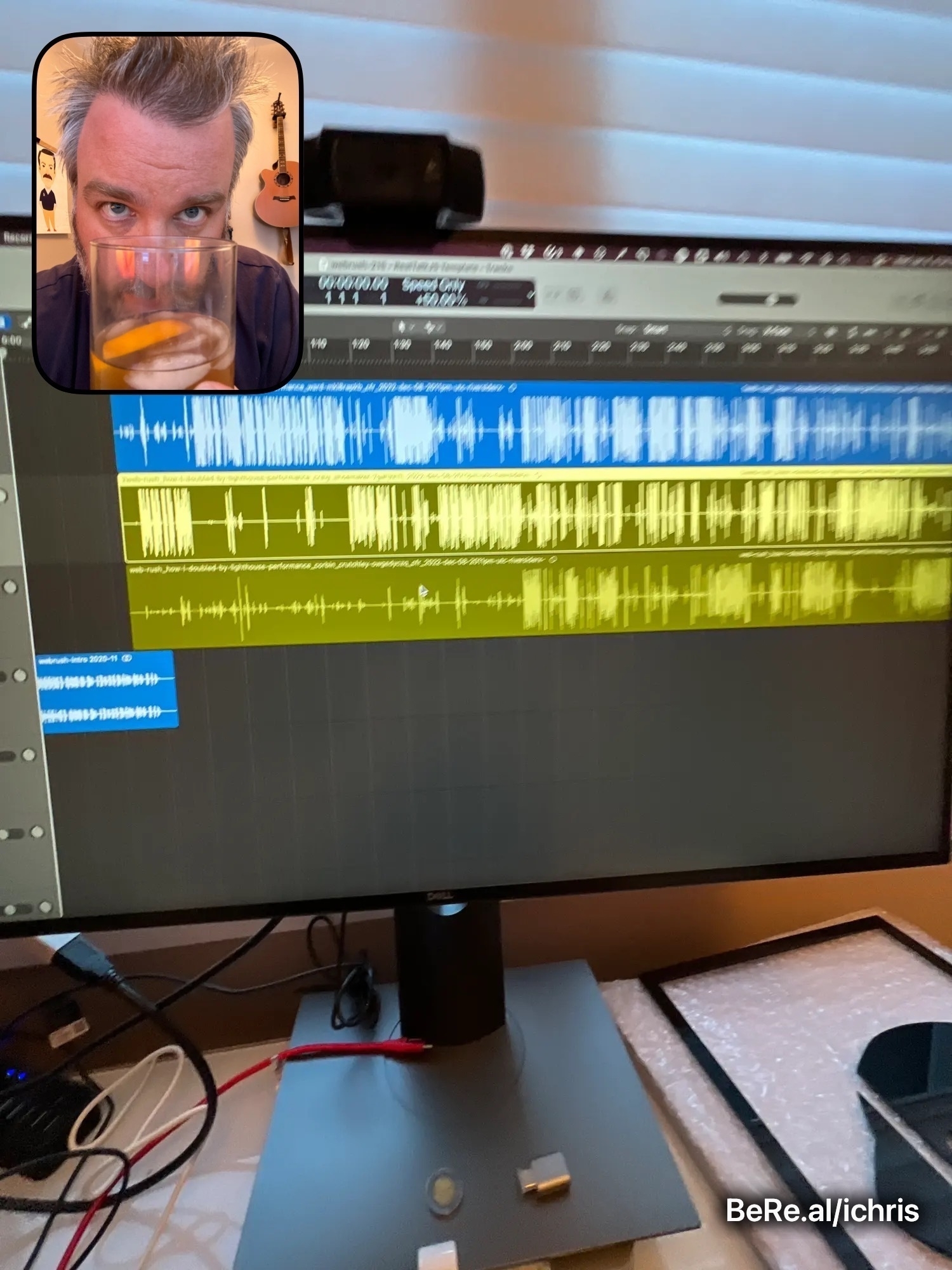 BeReal of me having an old fashioned drink with a computer monitor showing Logic Pro tracks from a podcast. 