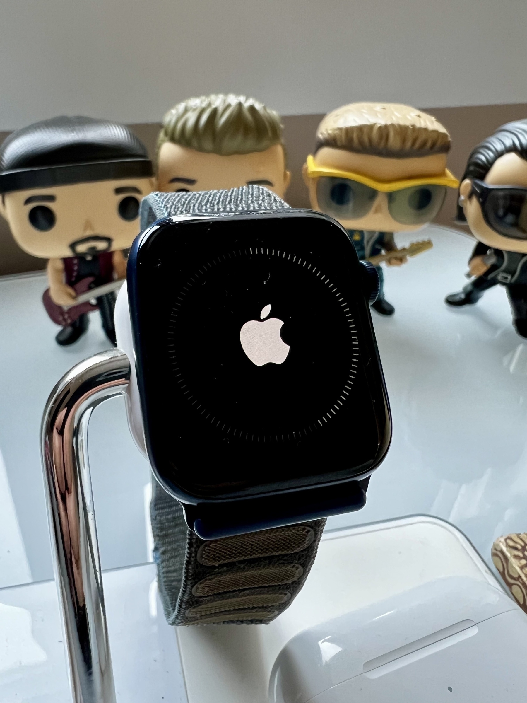 Apple Watch Series 6 updating to watchOS 10. Half way done. U2 Funko pop characters in the background. 