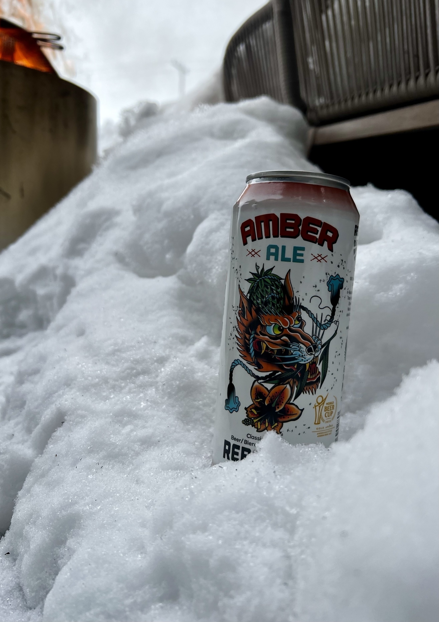 A can of Amber Ale rebellion brewery beer sits in snow. 