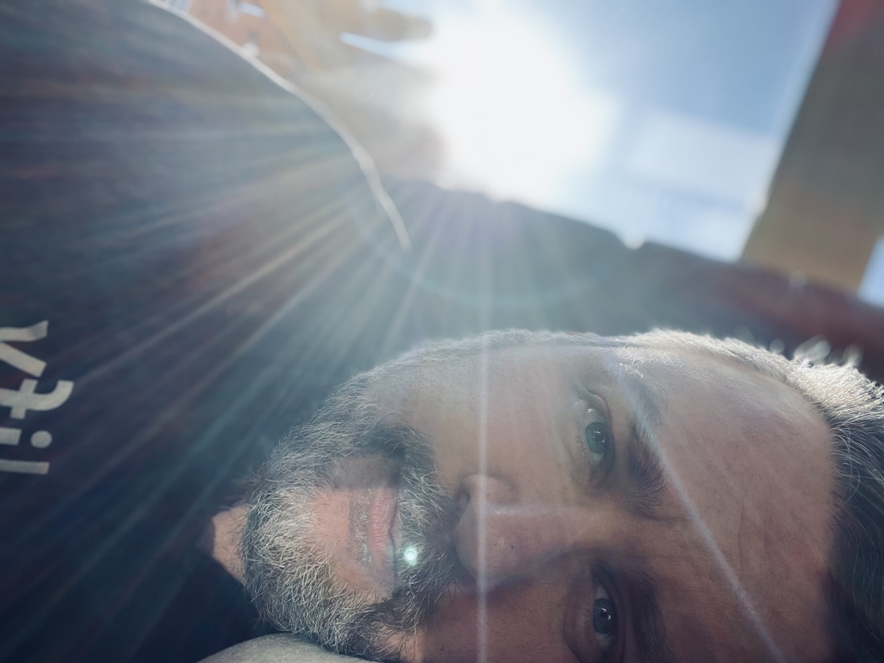 Me laying sideways with a sun flare over my head