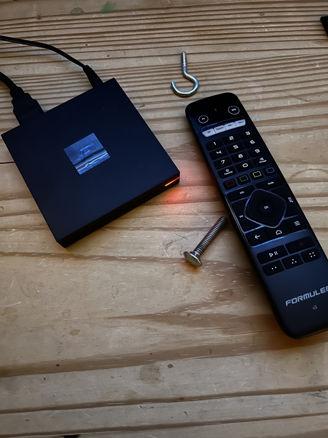 A IPTV box and a remote siting on a table. 