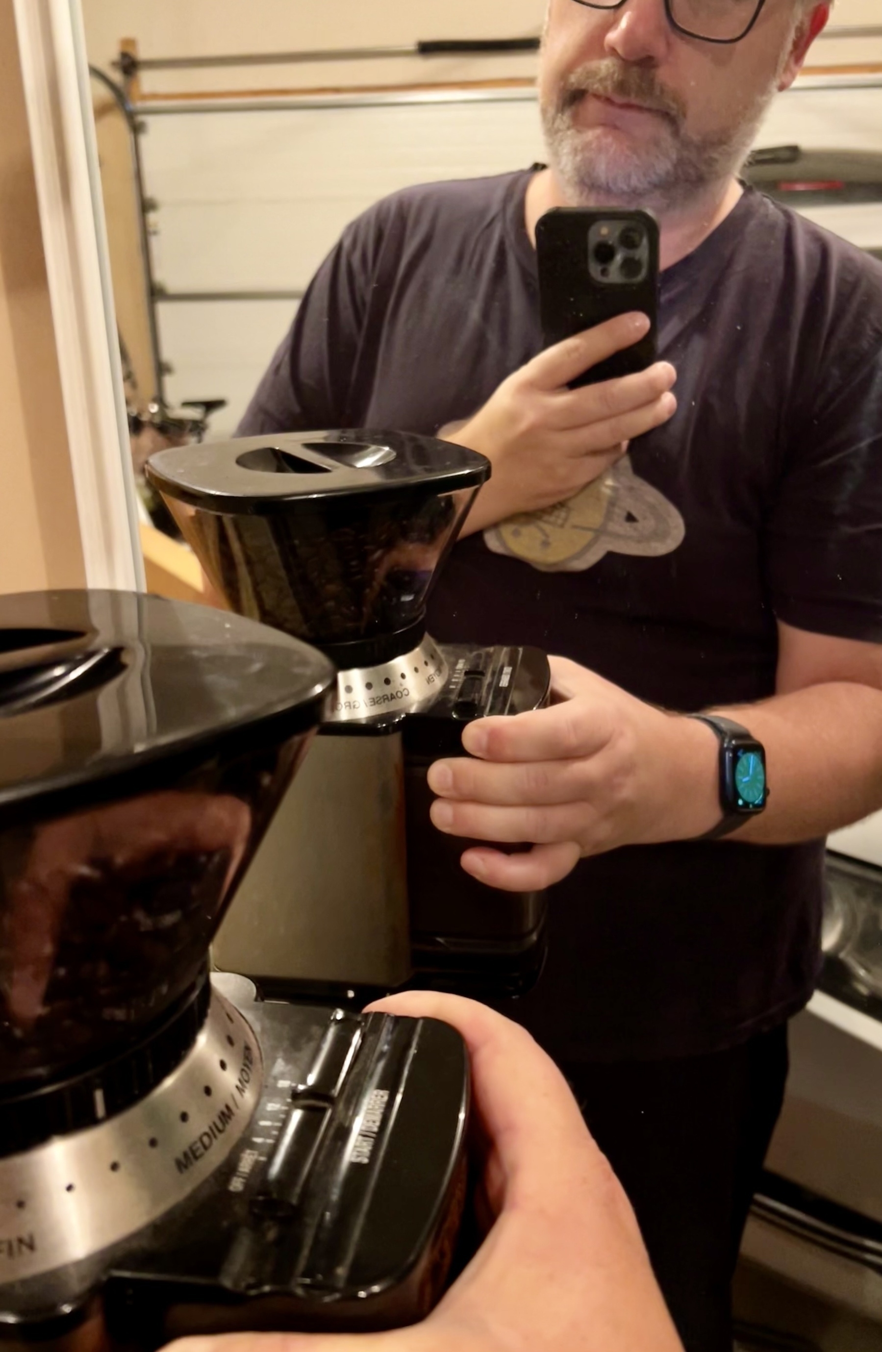 Me holding a coffee grinder in a garage while it’s grinding beans. 