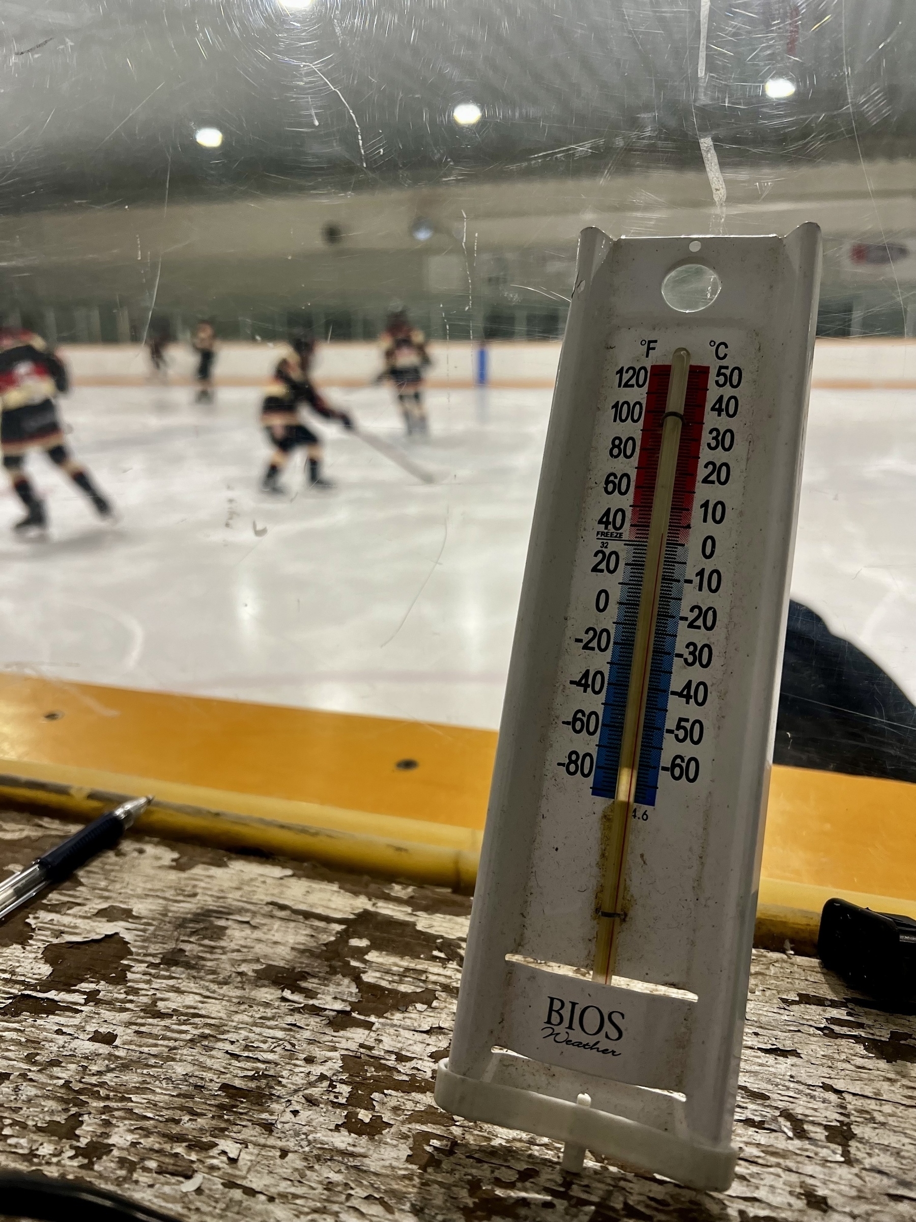 A thermometer is displayed prominently in a hockey rink, showing the temperature at 1C as players skate in the background.