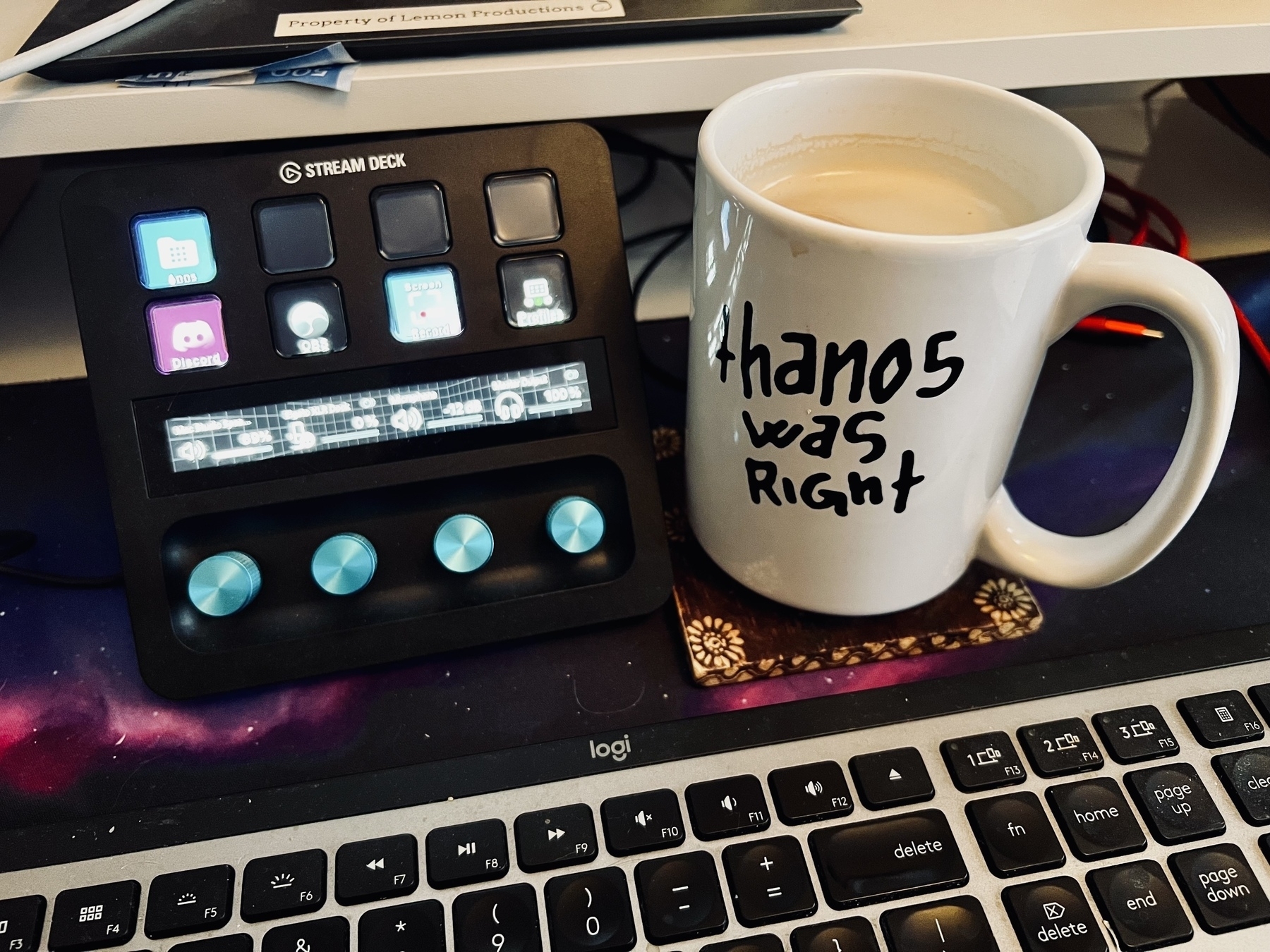 A Stream Deck and a mug with the phrase thanos was right are placed on a desk beside a keyboard.