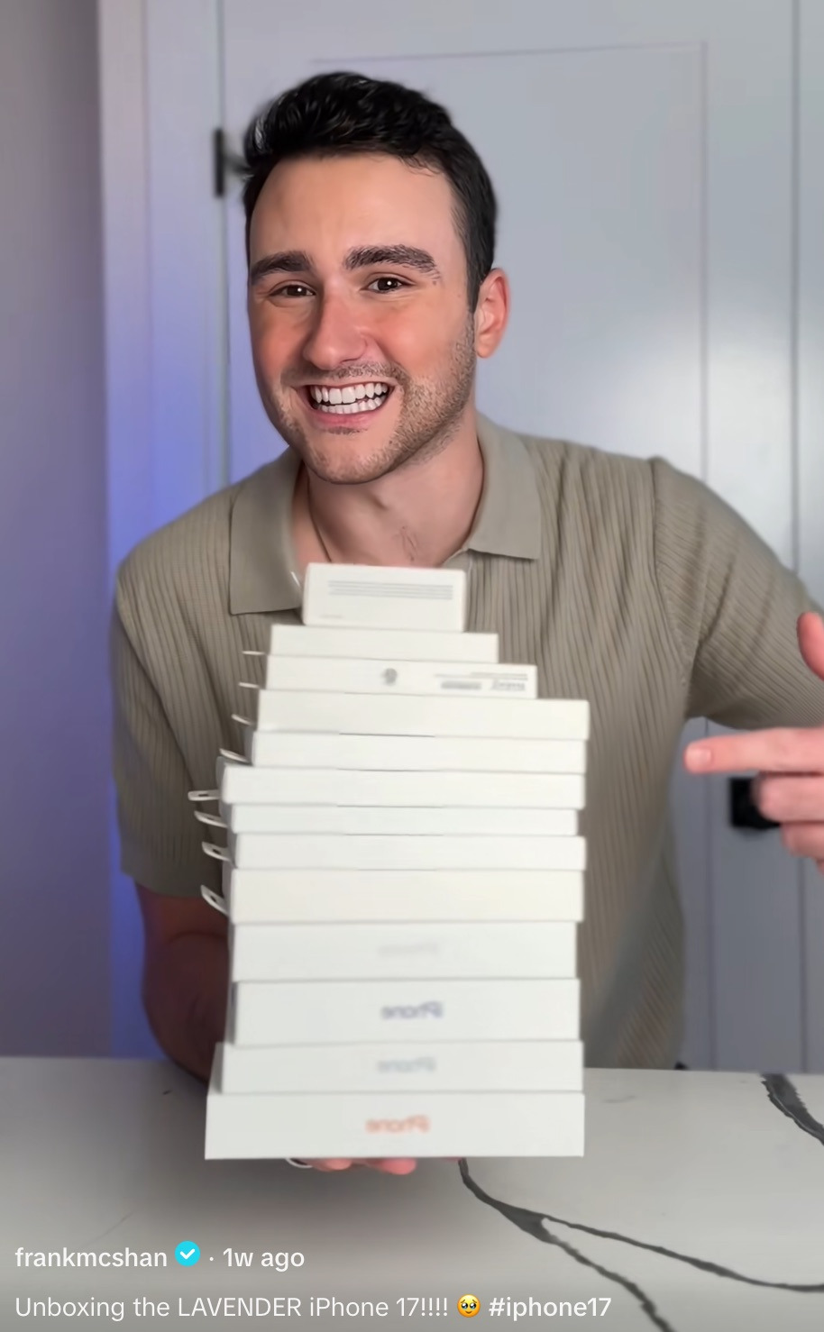 A screenshot from a tktok showing user @frankmcshan holding 15 boxes of iphones stacked on top of each other.