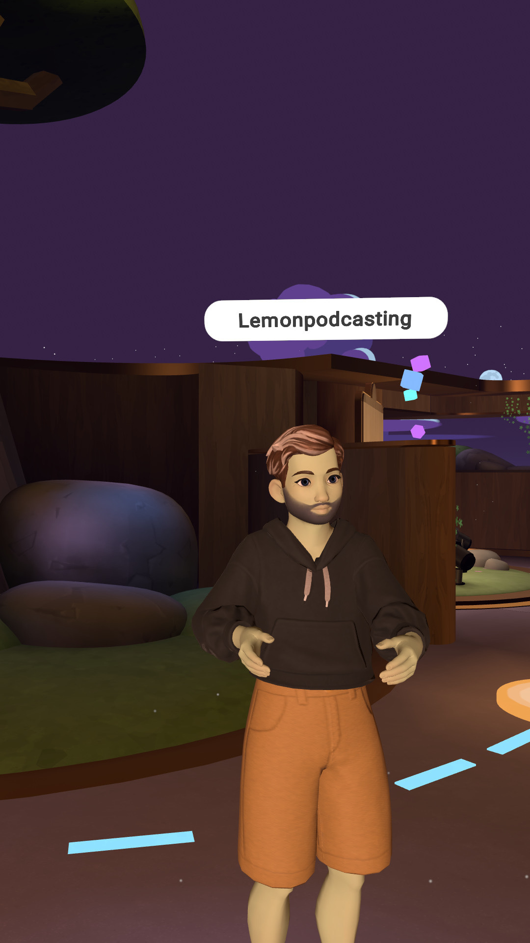 A cartoon-like character with a beard and short hair is standing in a Horizons virtual environment, wearing an orange hoodie and shorts, with the label "Lemonpodcasting" above.