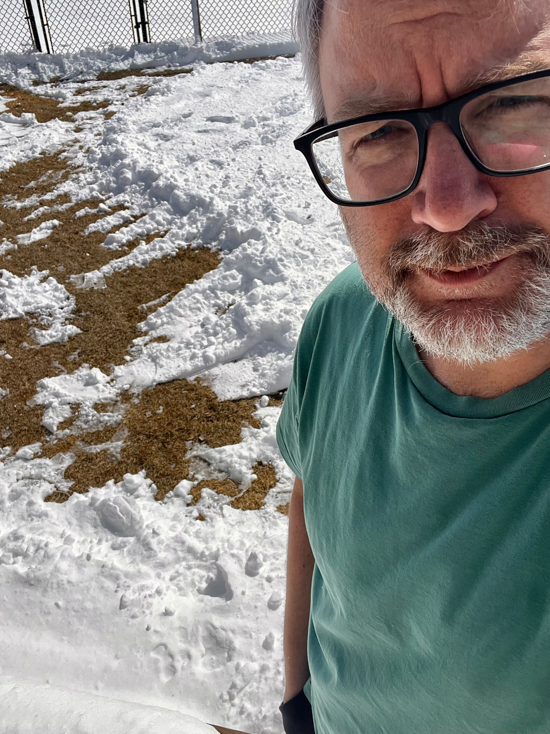 Me standing with snow and a patch of grass behind me. 