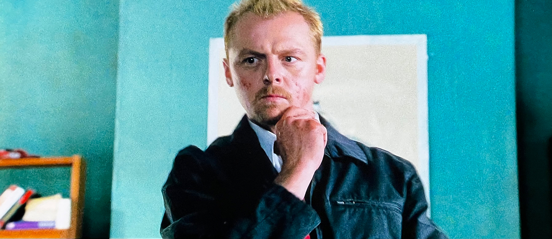 Still frame from Shaun of the dead where star Simon pig is standing facing the camera about to explain his plan for avoiding zombies. ￼