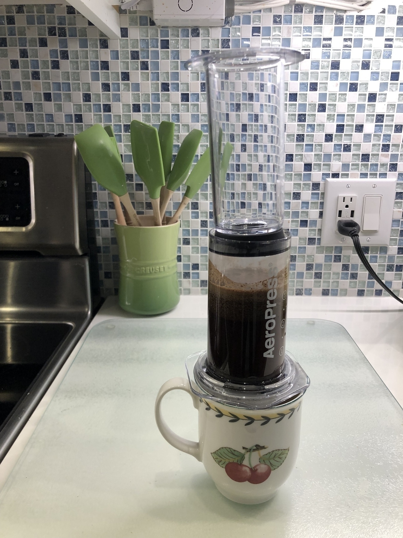An AeroPress filled with brewing coffee on a kitchen counter