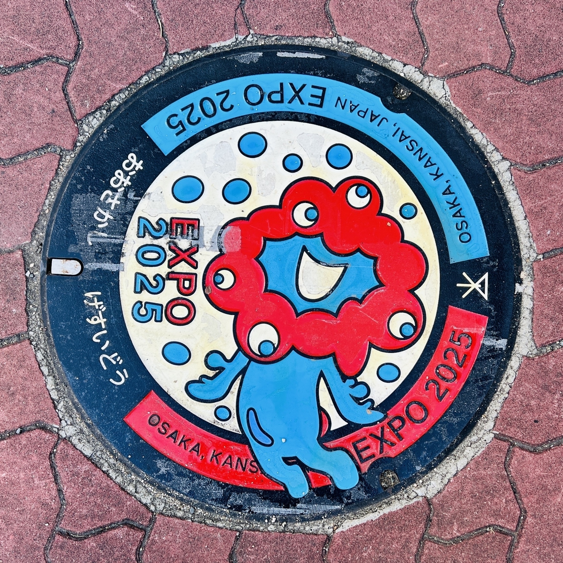 Manhole cover featuring Myakumyaku, the mysterious 5-eyed amoeba-like mascot for the 2025 Osaka Expo