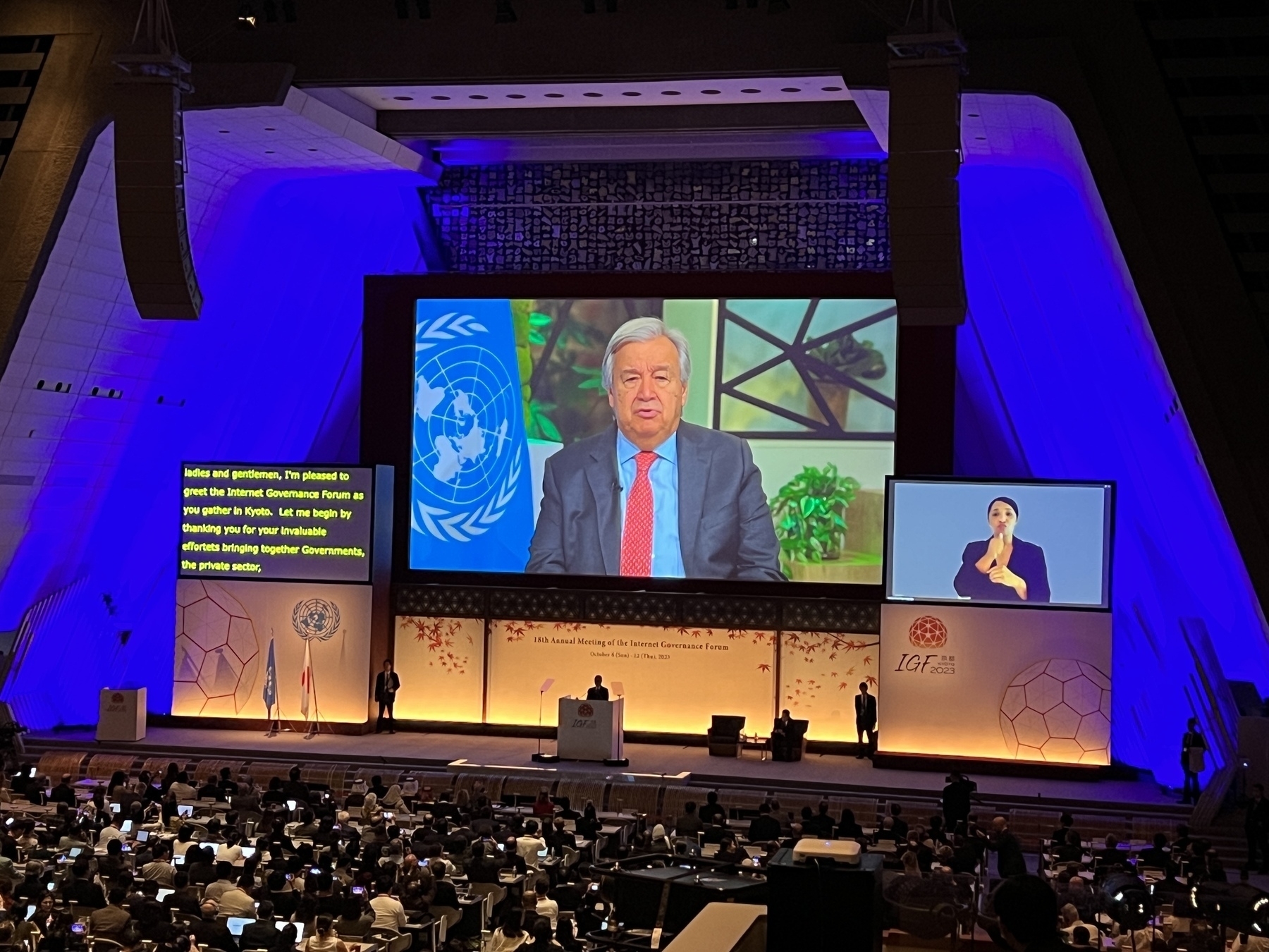 UN Secretary General Antonio Guterres delivers a speech from a large screen