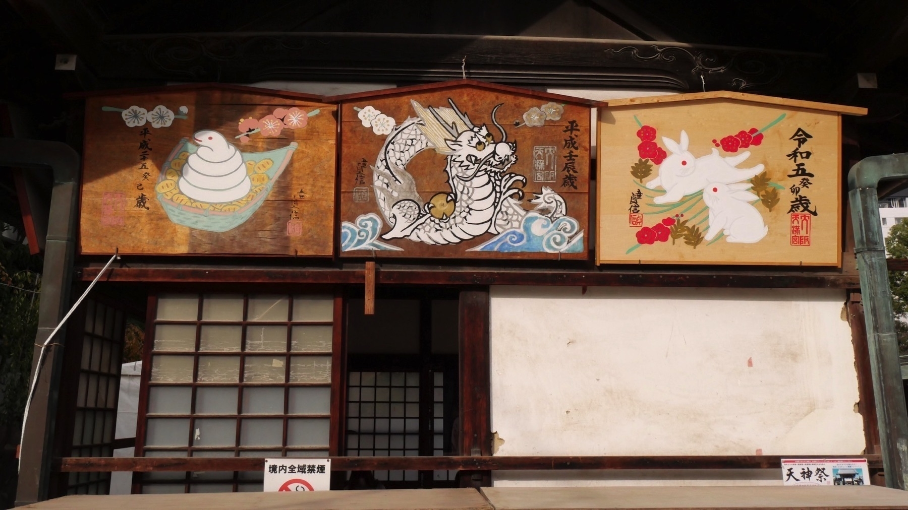 Large paintings of three zodiac animals with the associated year above a shrine window. From right to left: Rabbit - Reiwa 5; Dragon Heisei - 24; Snake - Heisei 25. 