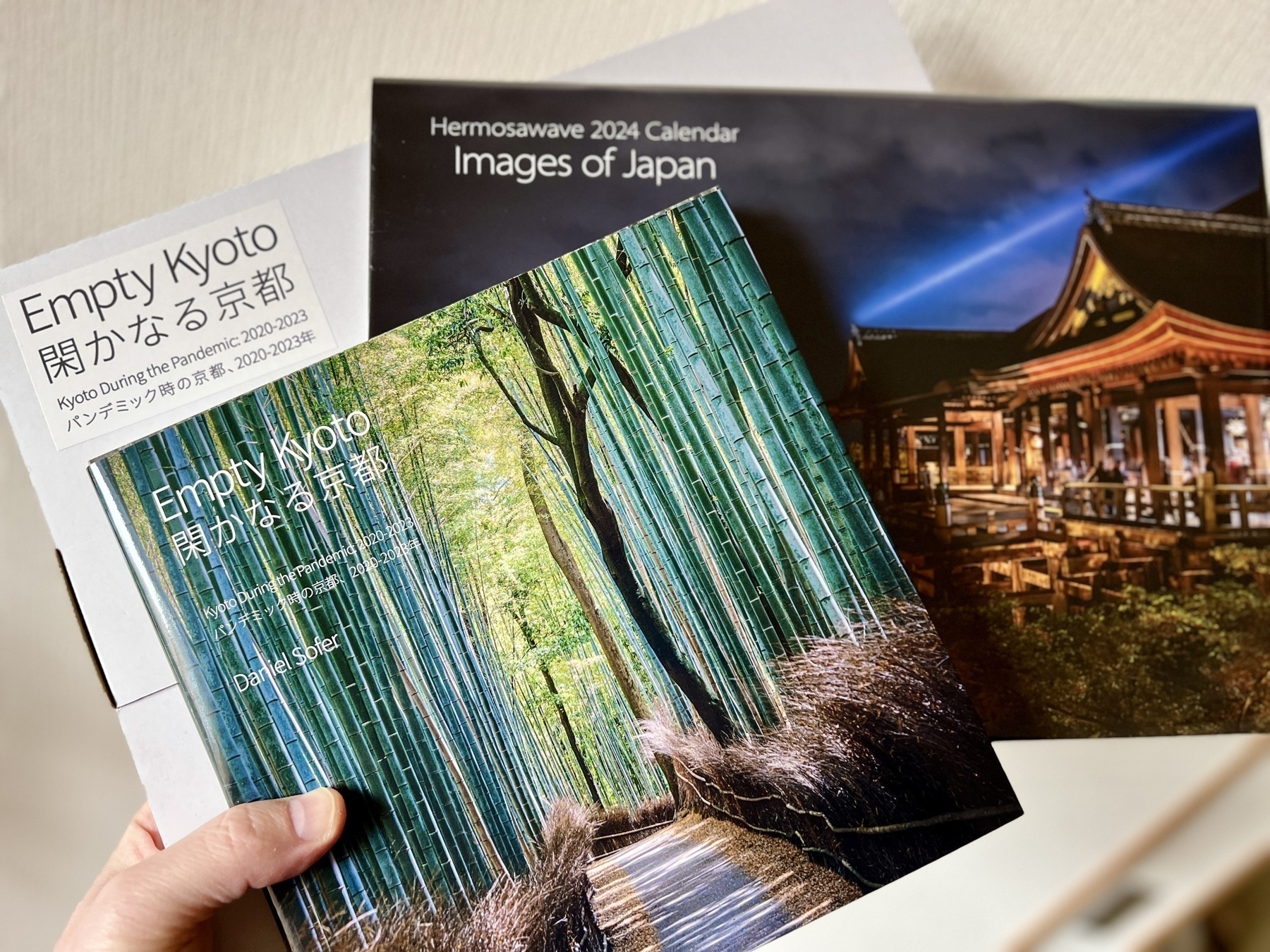 Chad holds up the book (cover showing the bamboo grove of Arashiyama), calendar (with a night shot of Kiyomizudera), and the box the book came in
