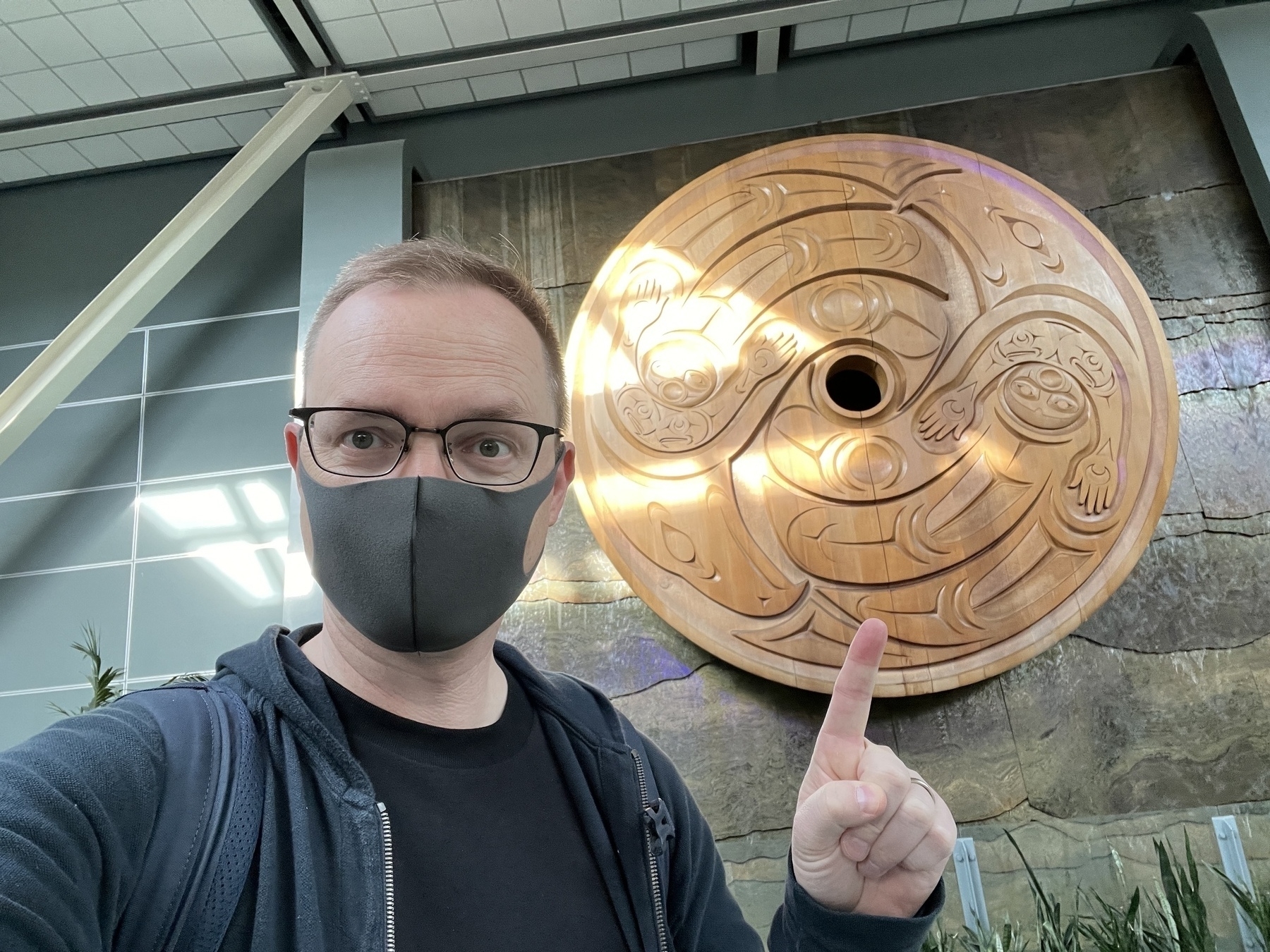 Chad selfie in front of the famous carving at YVR airport