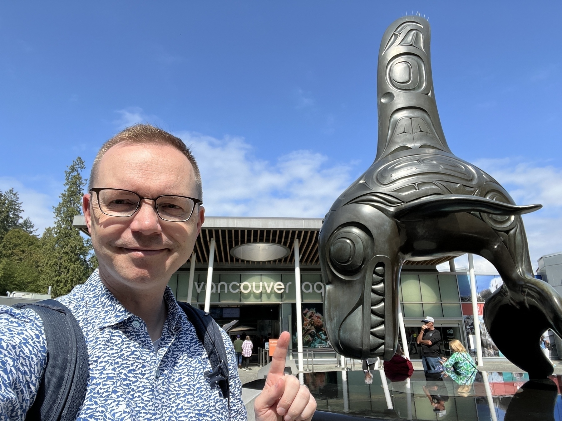 Chad selfie at the Vancouver Aquarium entrance, by the Haida carving of an orca