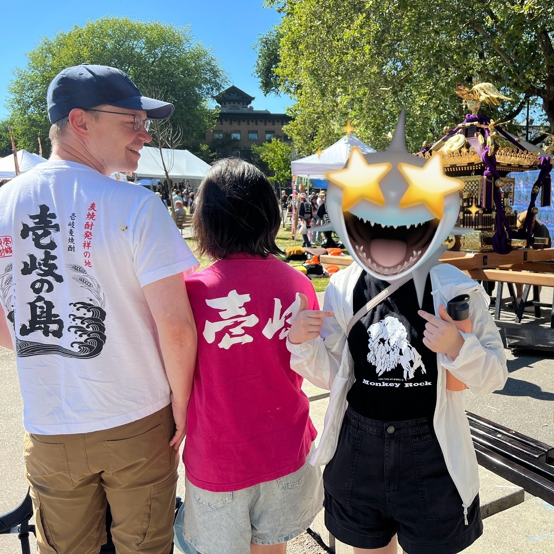 Chad and his daughter pose in front of a mikoshi wearing t-shirts from Ikijima