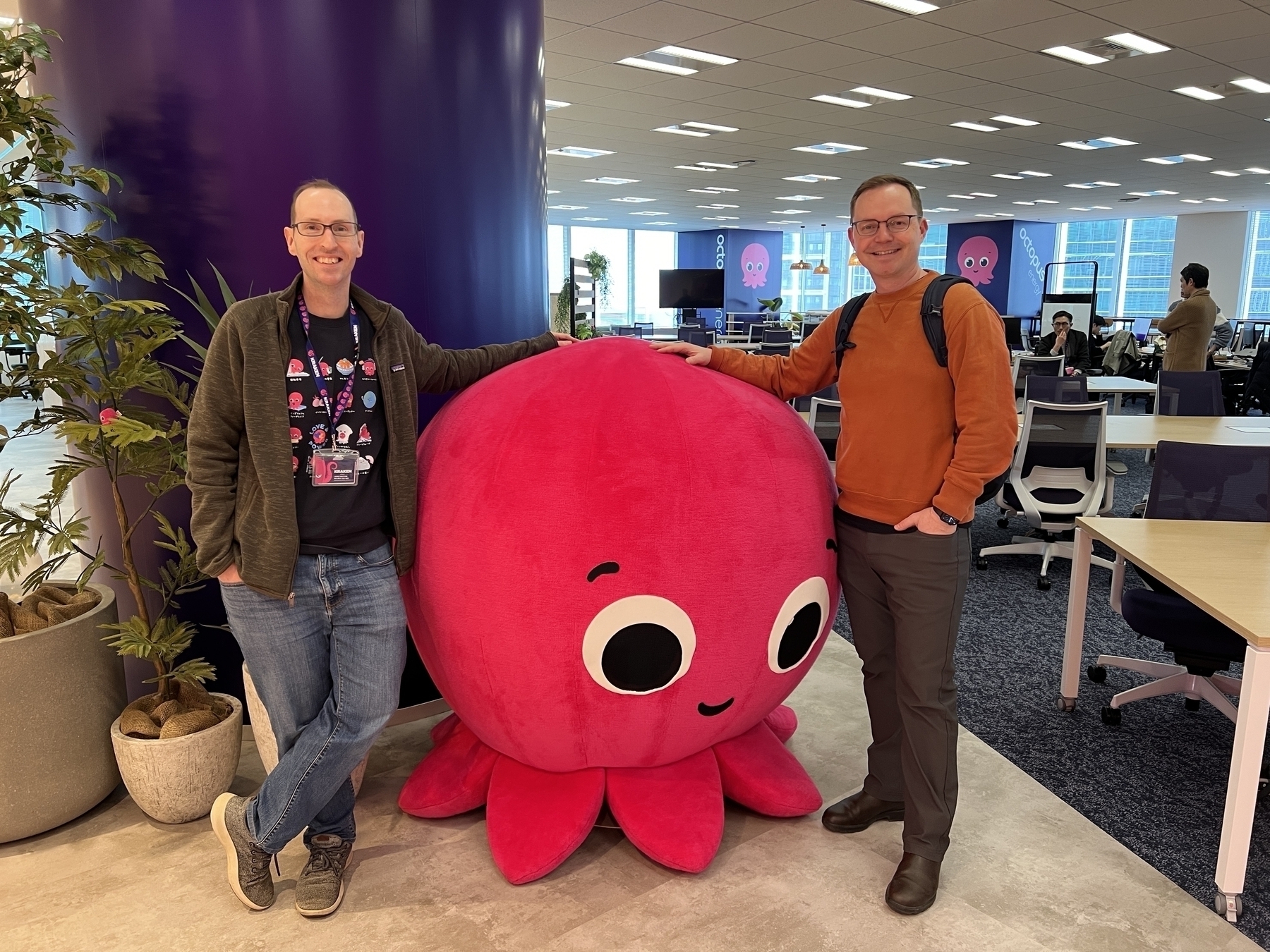James and Chad pose with Constantine, a 1.5m tall pink octopus plushie that is the mascot of octopus energy