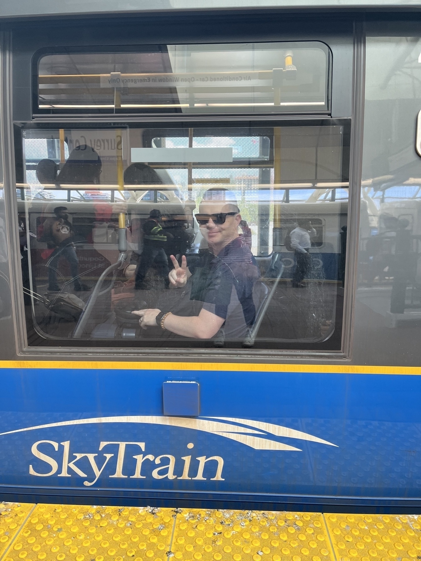 Chad gives the peace sign from inside the SkyTrain