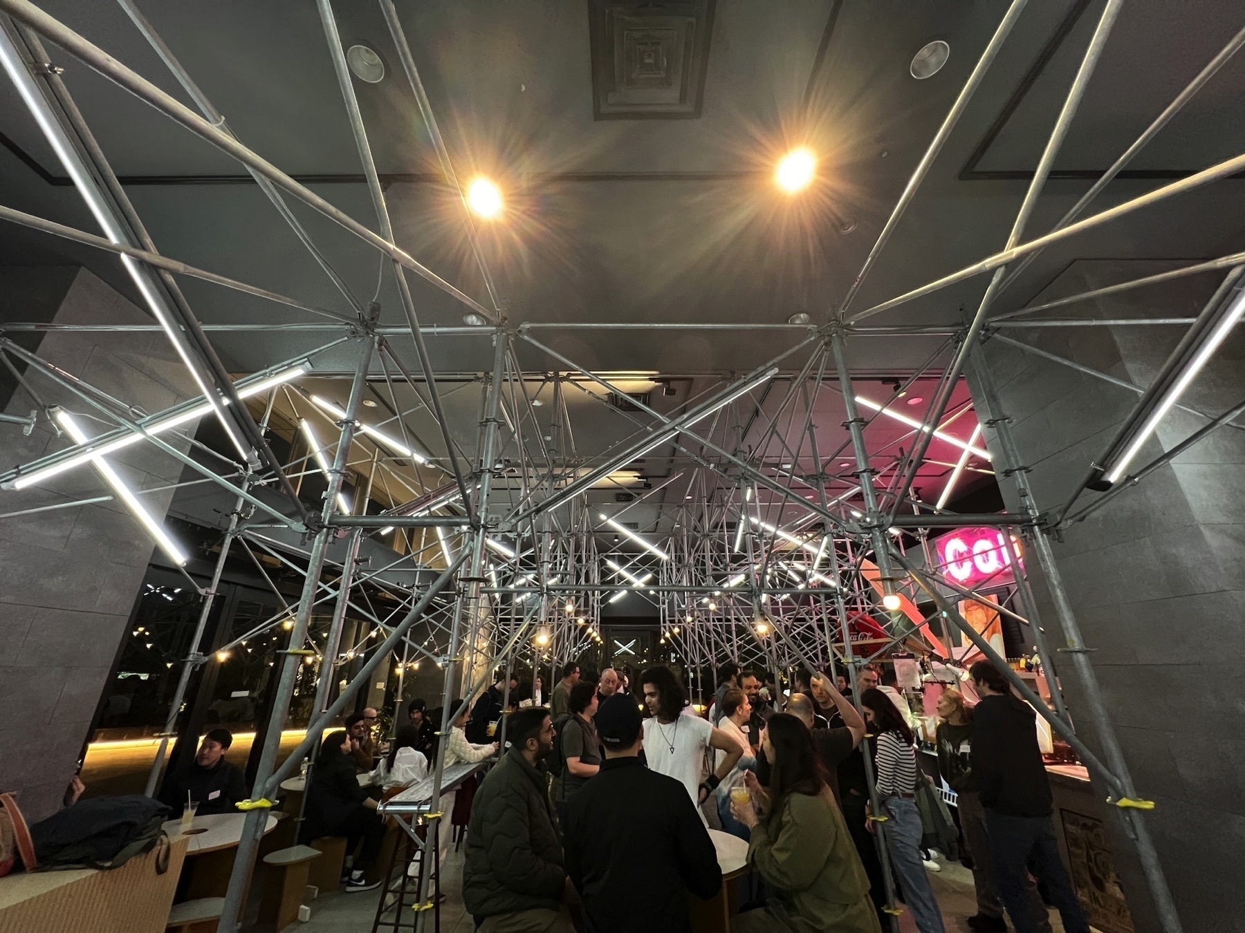People gathered in bar restaurant under some decorative scaffolding