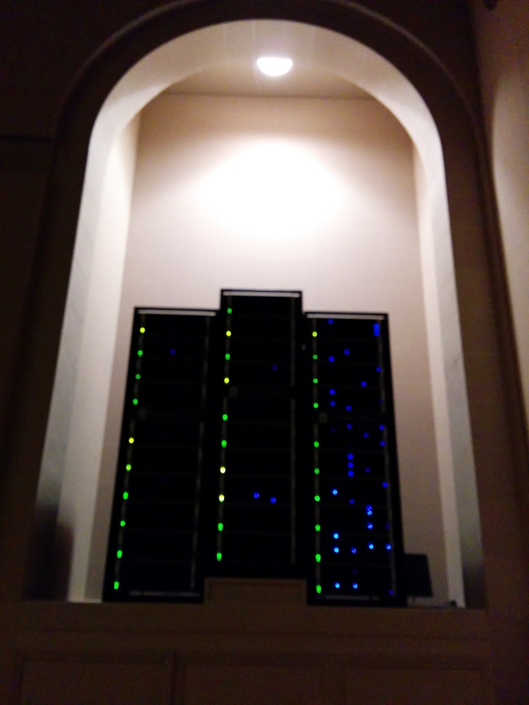 Server rack with blinky lights in a church alcove that probably housed some religious statue a long time ago