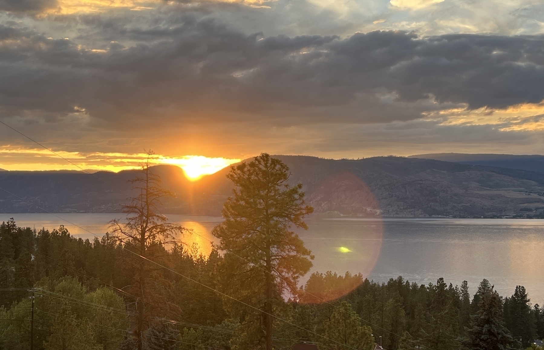 Sun sets behind mountains across the lake