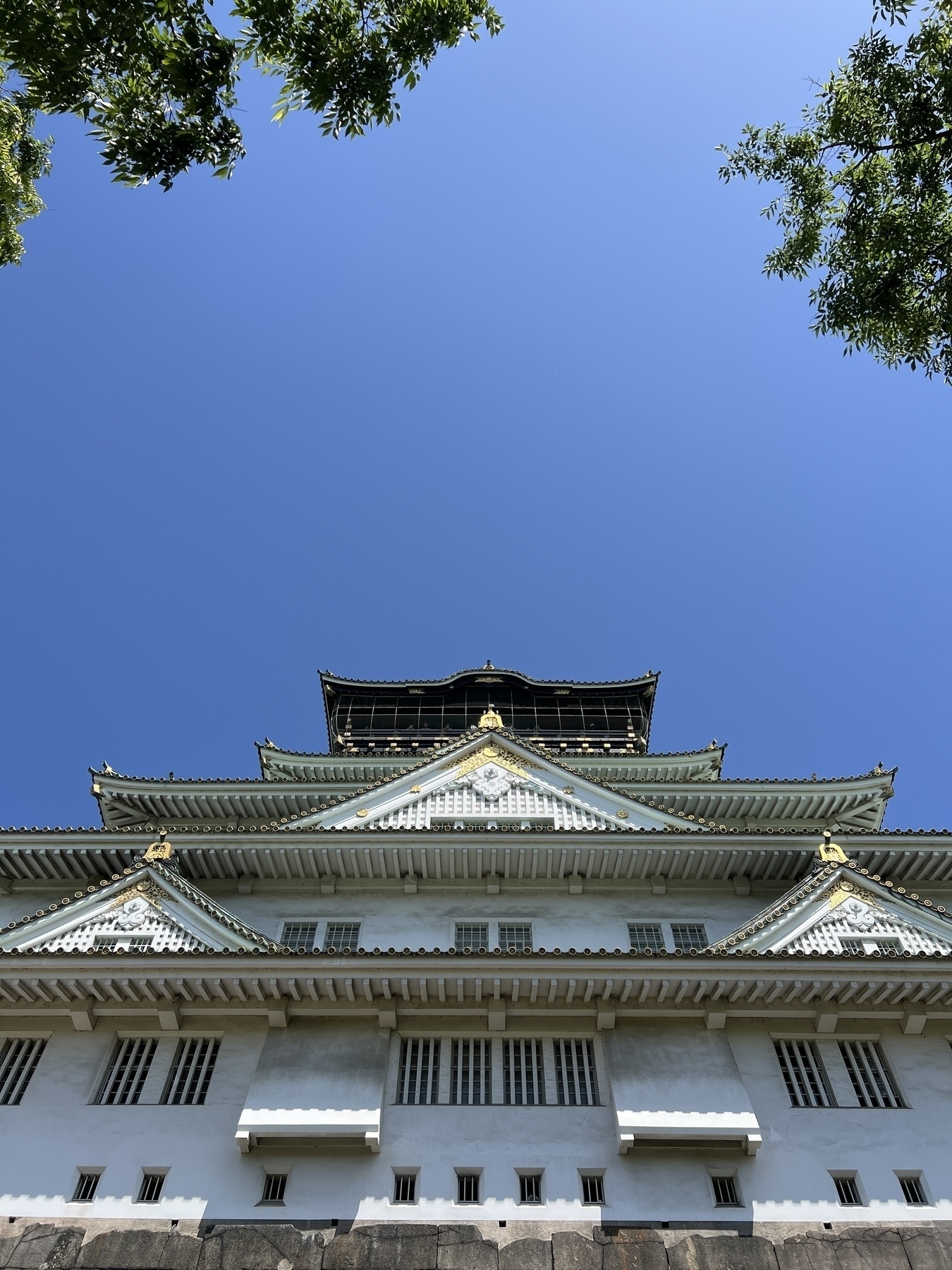 Looking up at Osaka castle, the brass fittings glitter in the sunlight