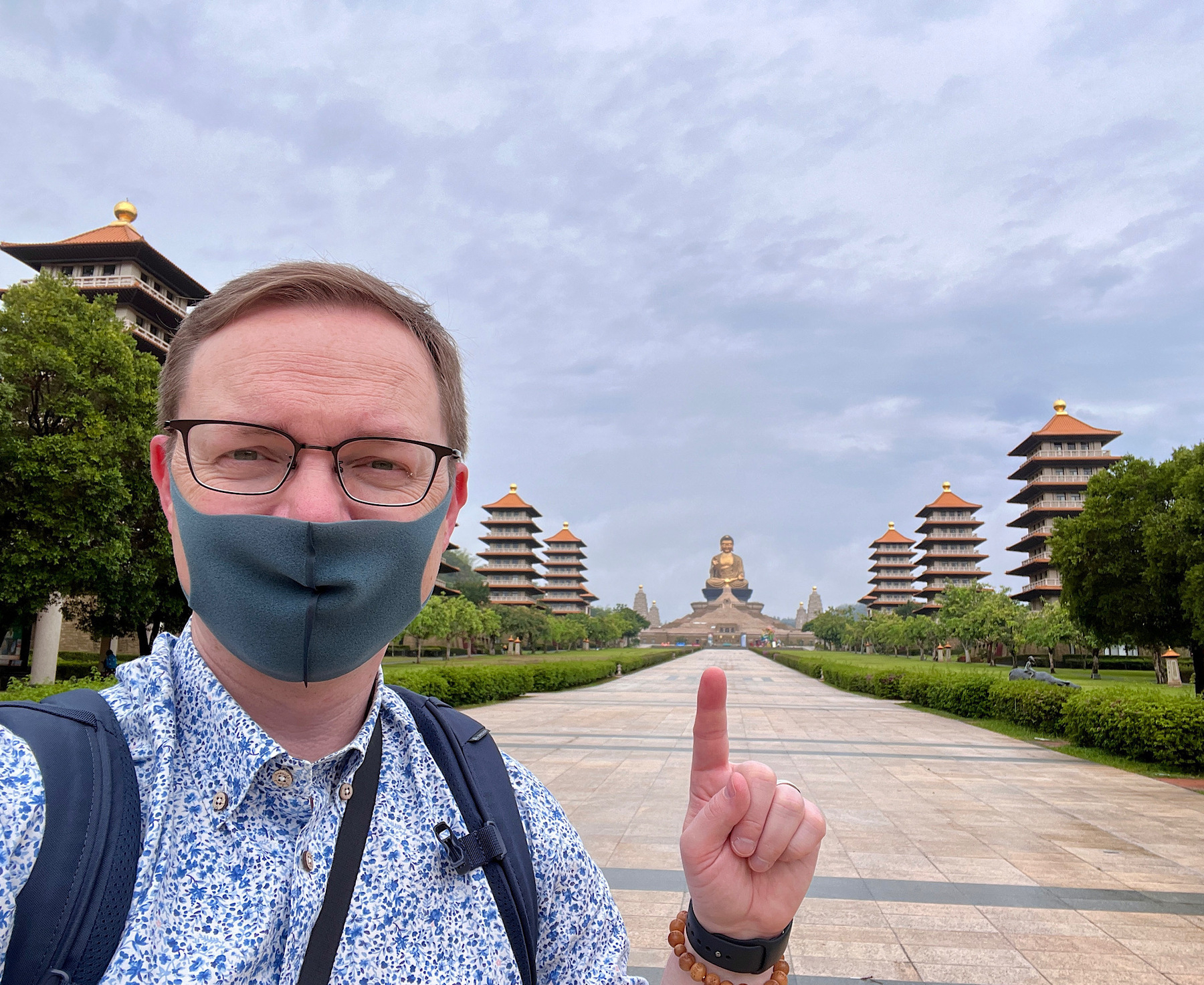 Chad selfie pointing to the Buddha statue from a distance