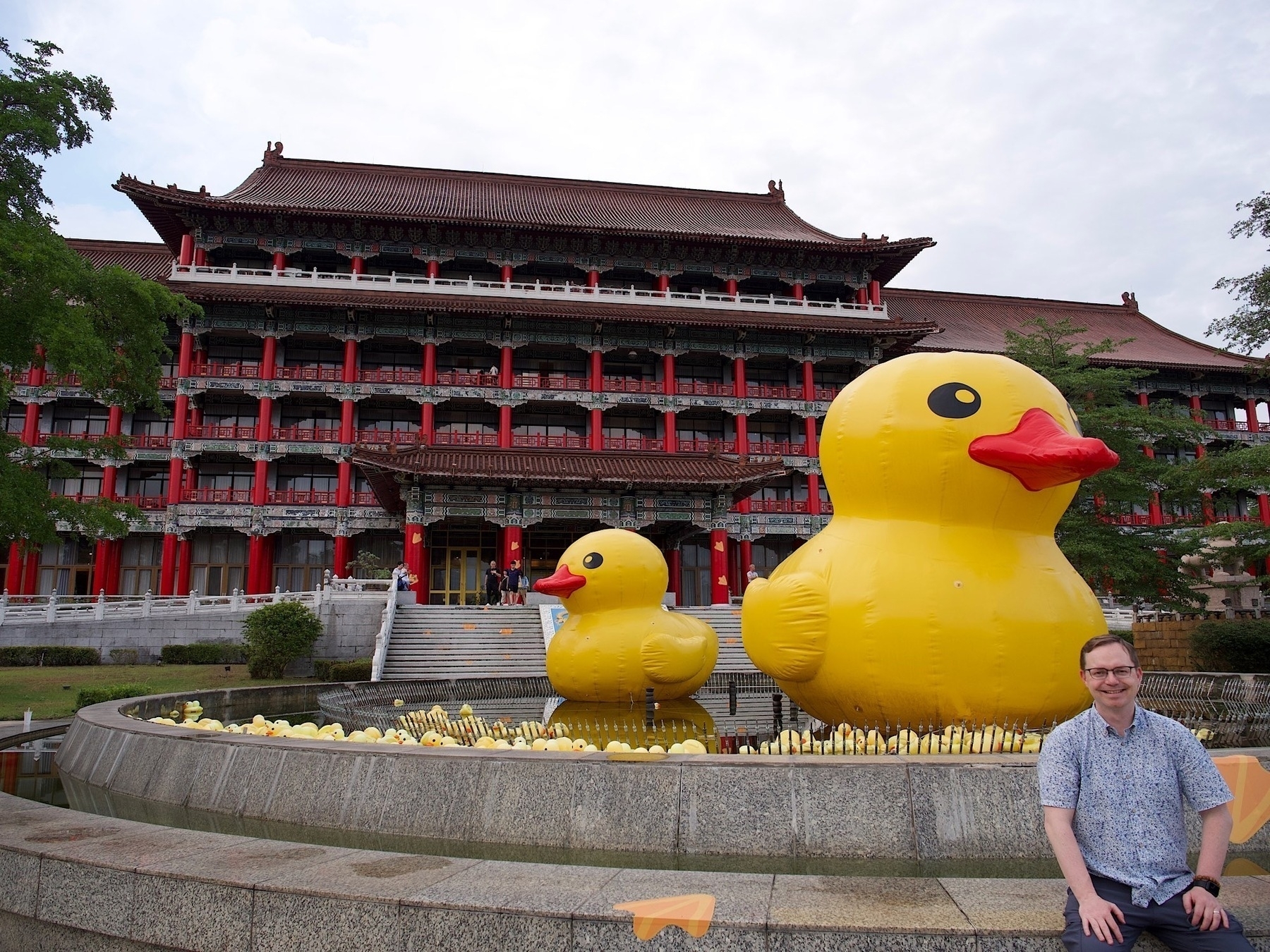 Chad sits in front of the fountain of the Grand Kaohsiung Hotel. In the fountain is a giant yellow rubber ducky