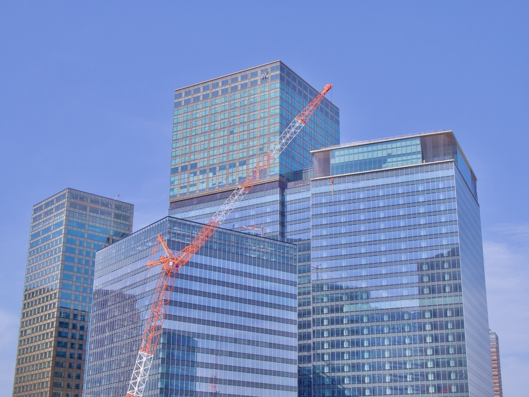 Some blue glass Umekita buildings with an orange-red building crane in front