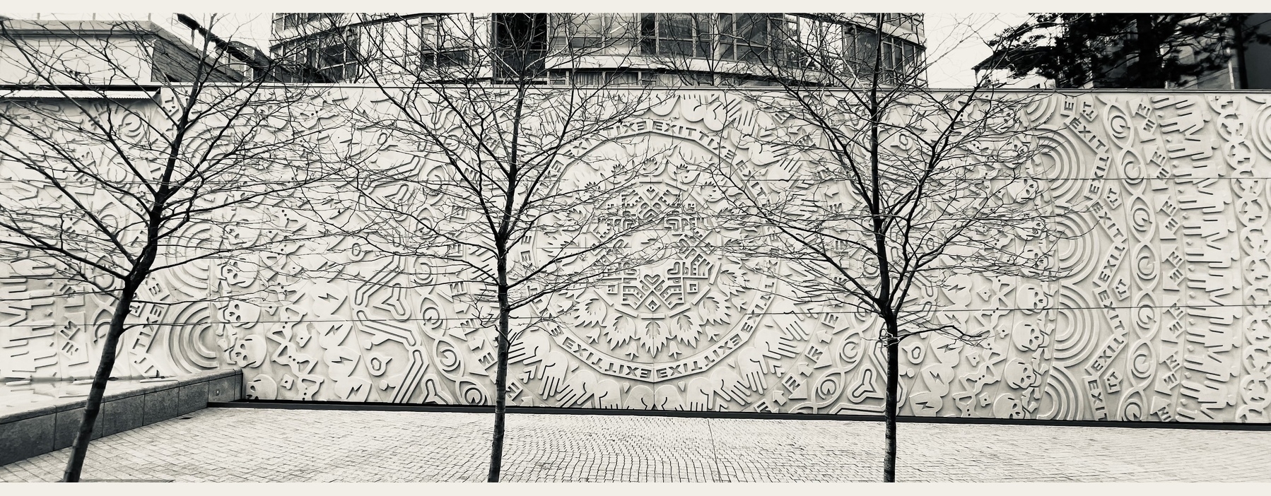 Wall art pattern in relief. There are lots of indigenous symbols radiating from the center with here there the words “IN” and “EXIT”. I need to look this up to figure out the meaning. 