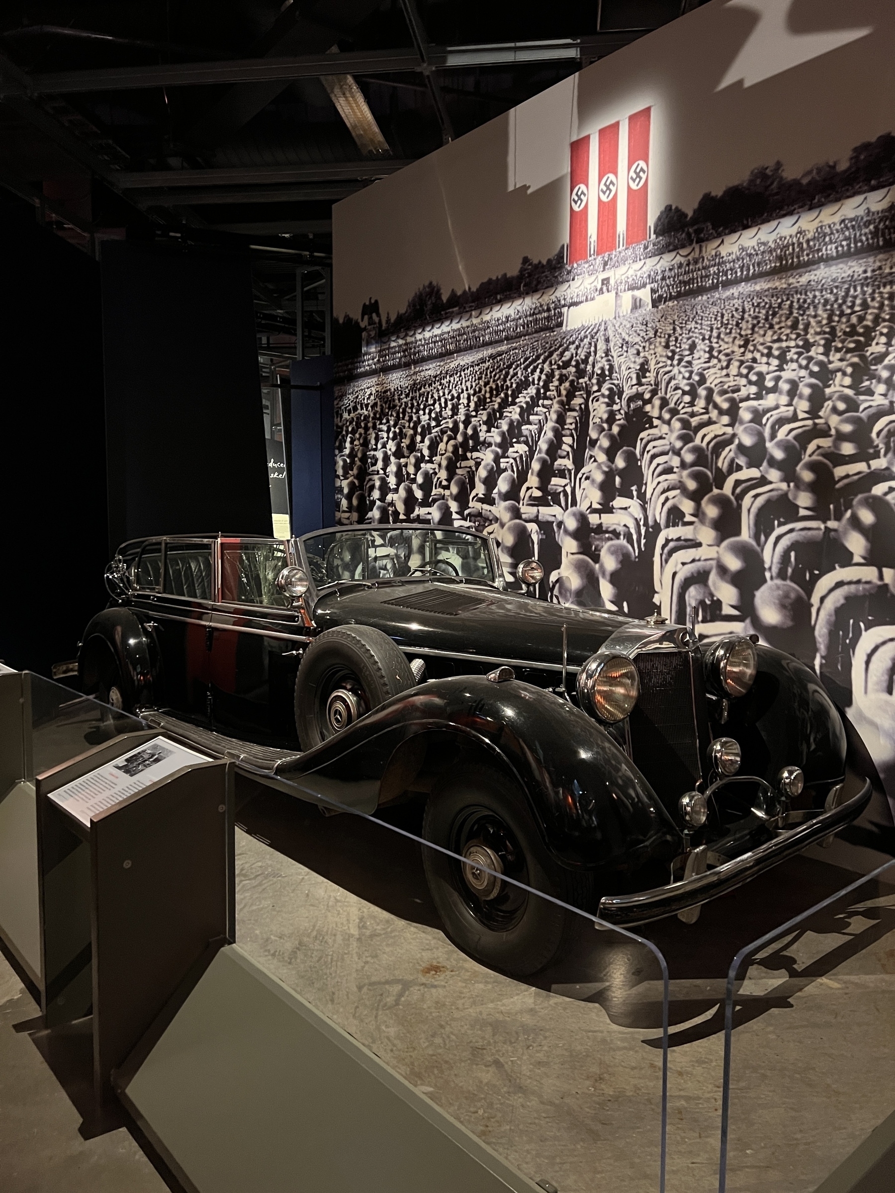 Hitler’s black parade car. In the background is a photo of a Nazi parade