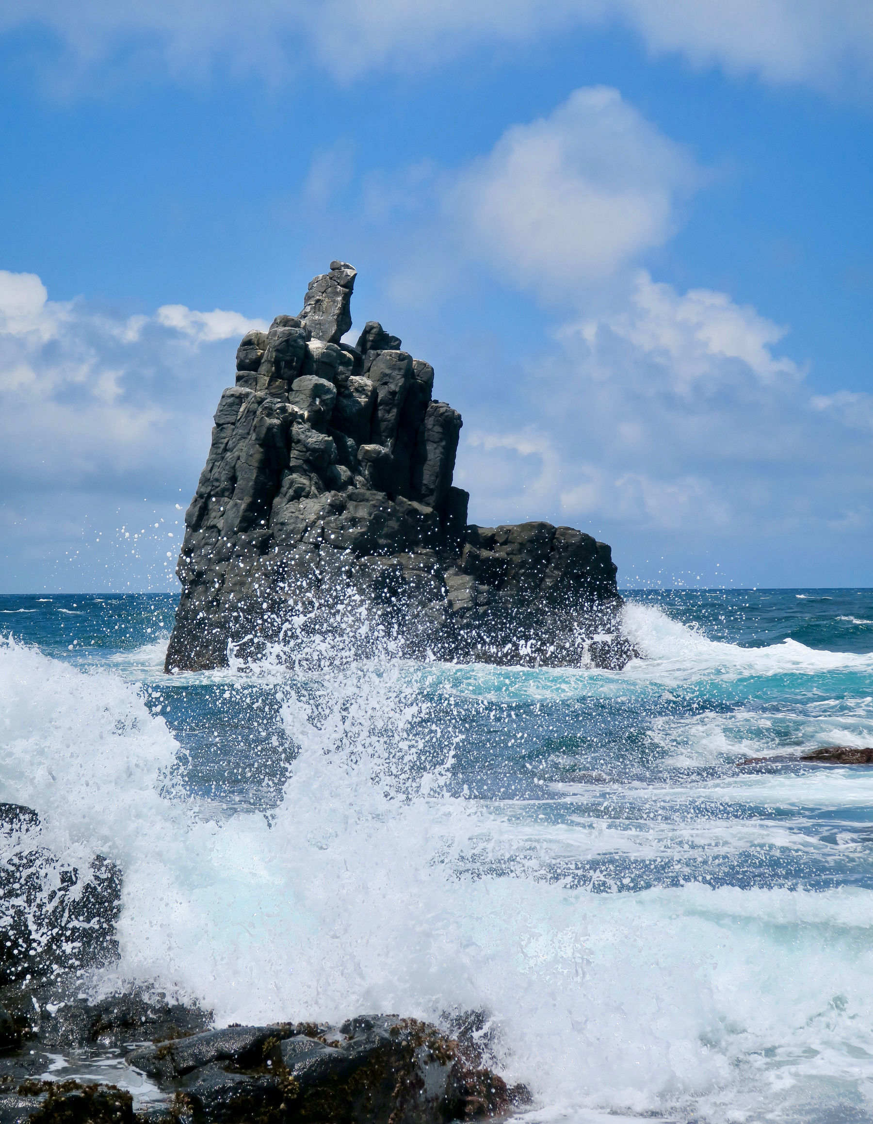 Waves crash on a rock formation in the ocean