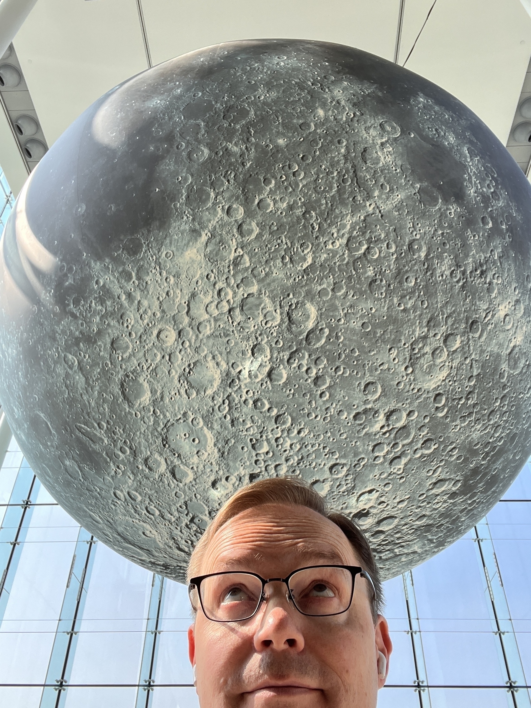 Chad selfie looking up at a giant model of the Moon