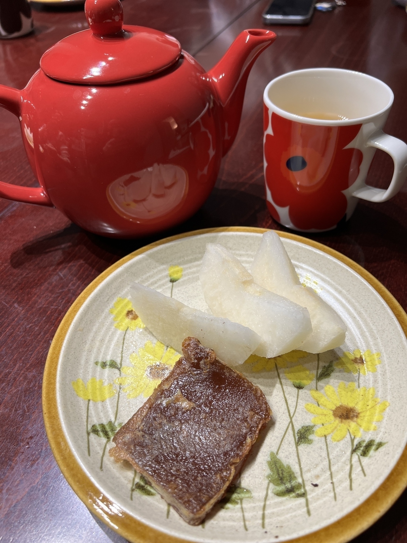 Pot of Taiwanese tea, slices of Asian pear, and a slice of fried rice cake