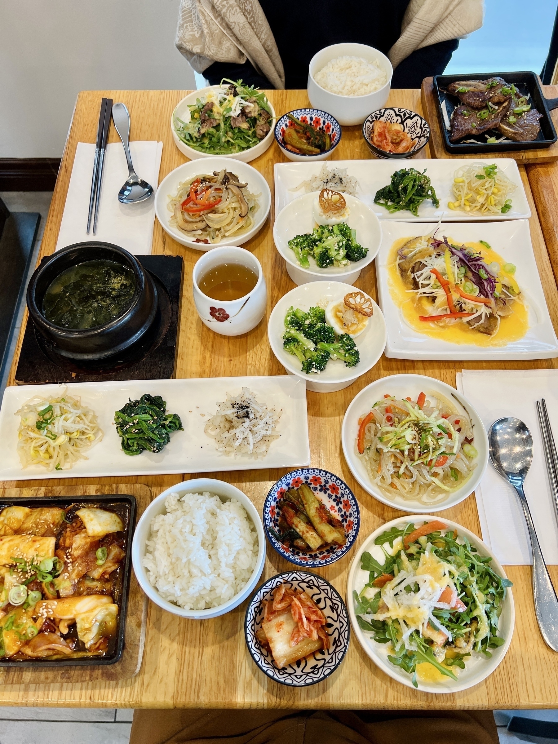 Many many small plates of Korean food absolutely covering a table