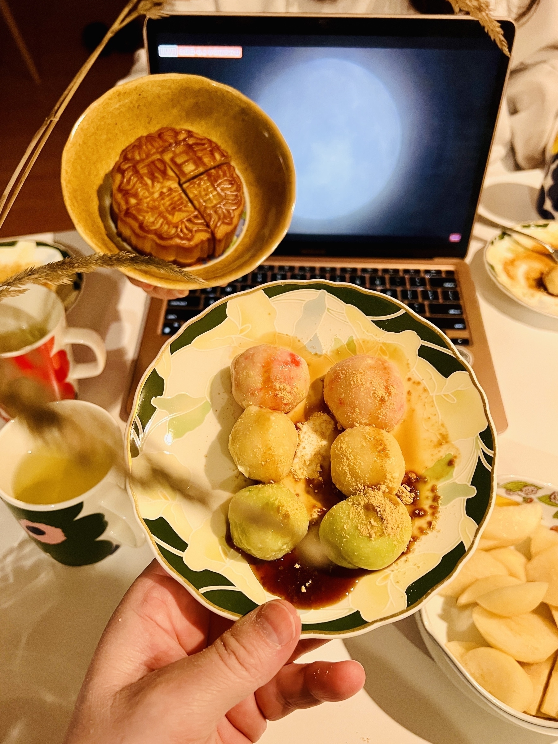 Plates of food with a laptop in the background displaying the full moon 