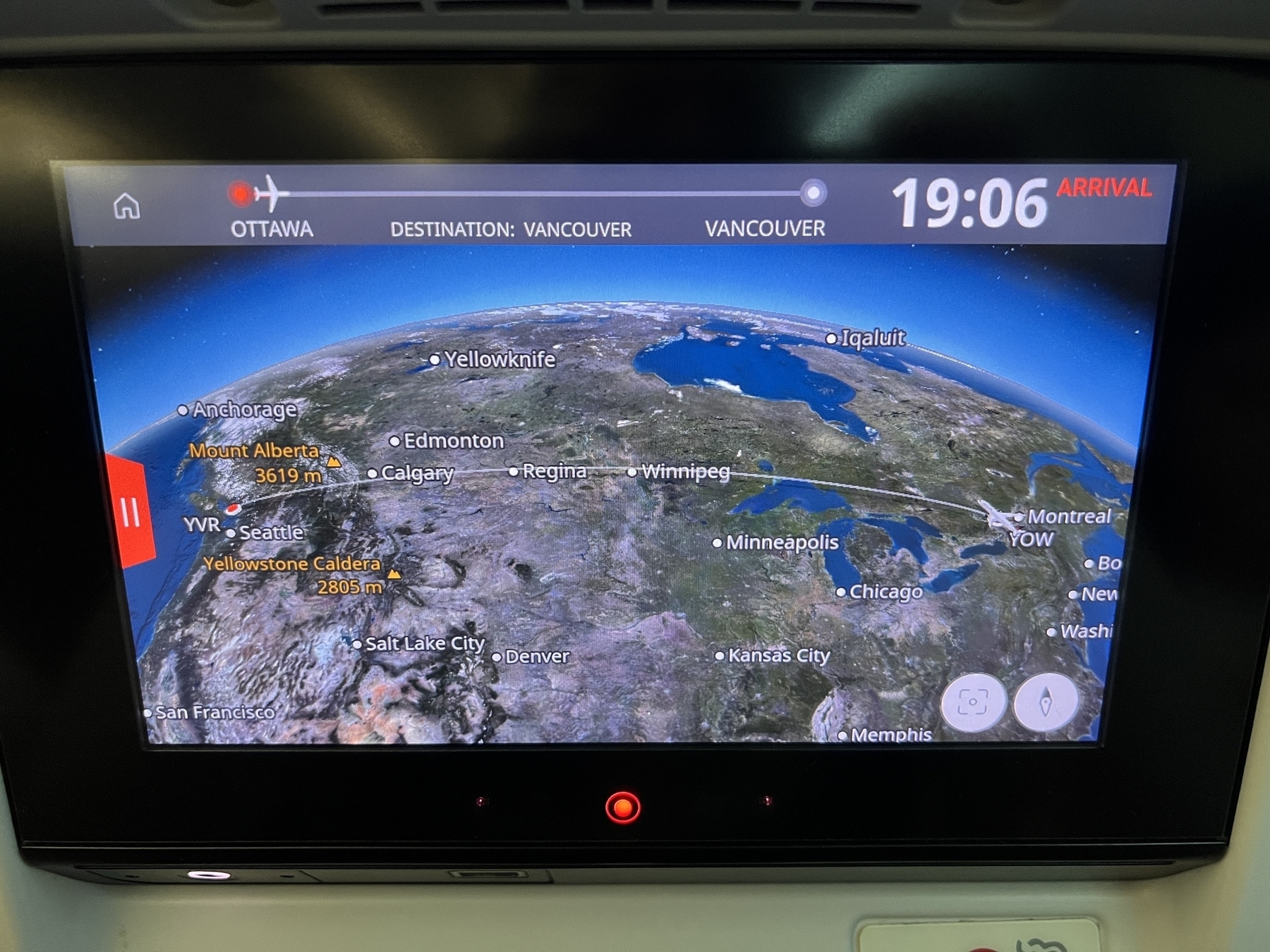Back of seat airplane monitor showing a map of Canada and an airplane route across the country from YOW to YVR