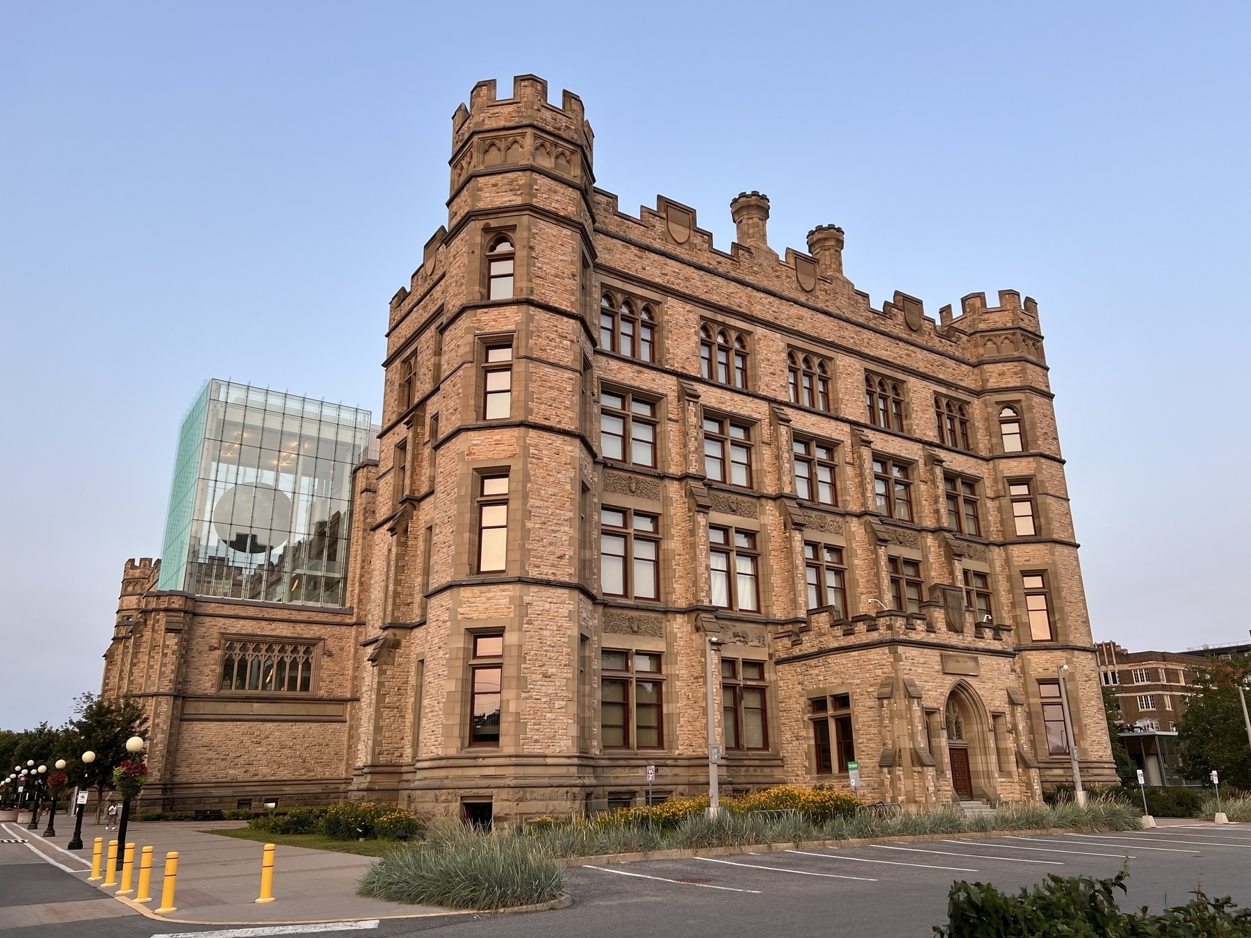 A castle like building made of stone, but on one side is a giant glass cube housing a model of the Moon