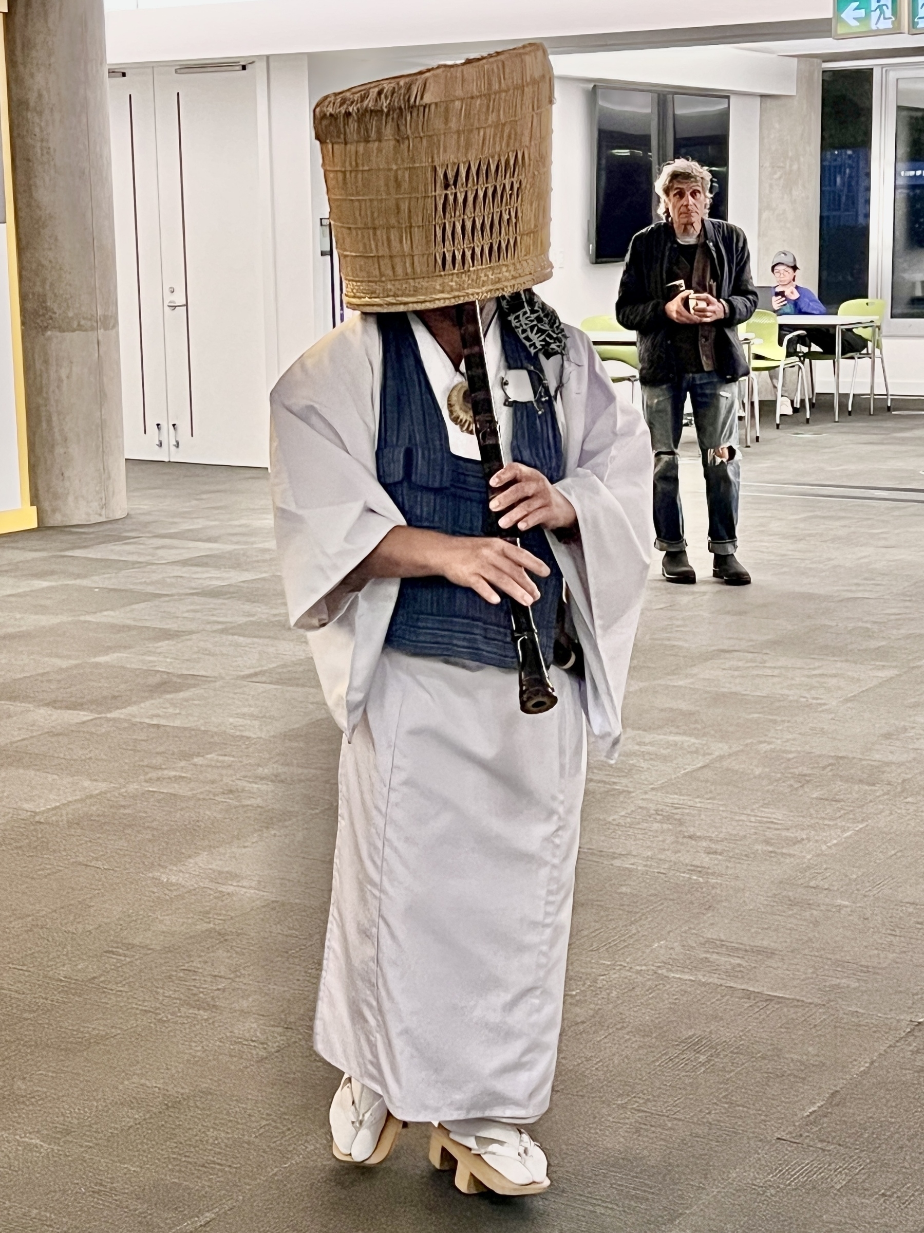 Man playing shakuhachi in the basket hat