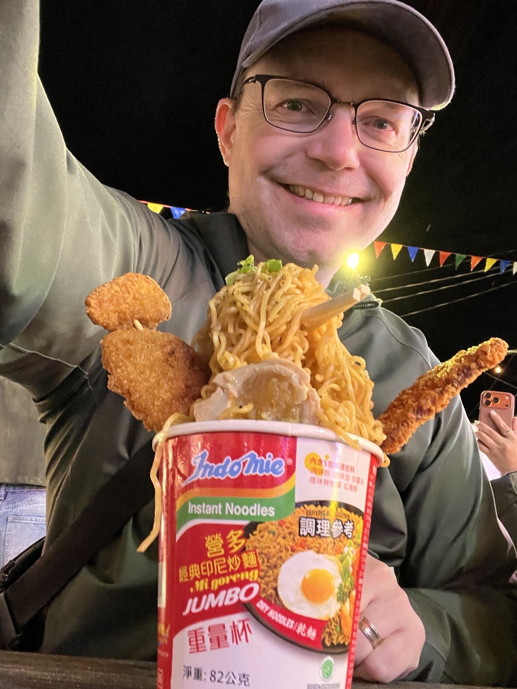 Chad selfie with “flying ramen” a noodle dish that looks like it is exploding out the cup