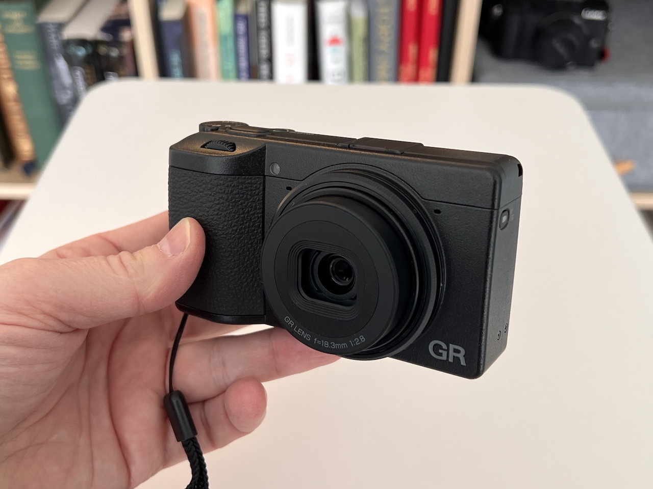 Chad holds the assembled Ricoh GRIV camera that is turned on with lense extended