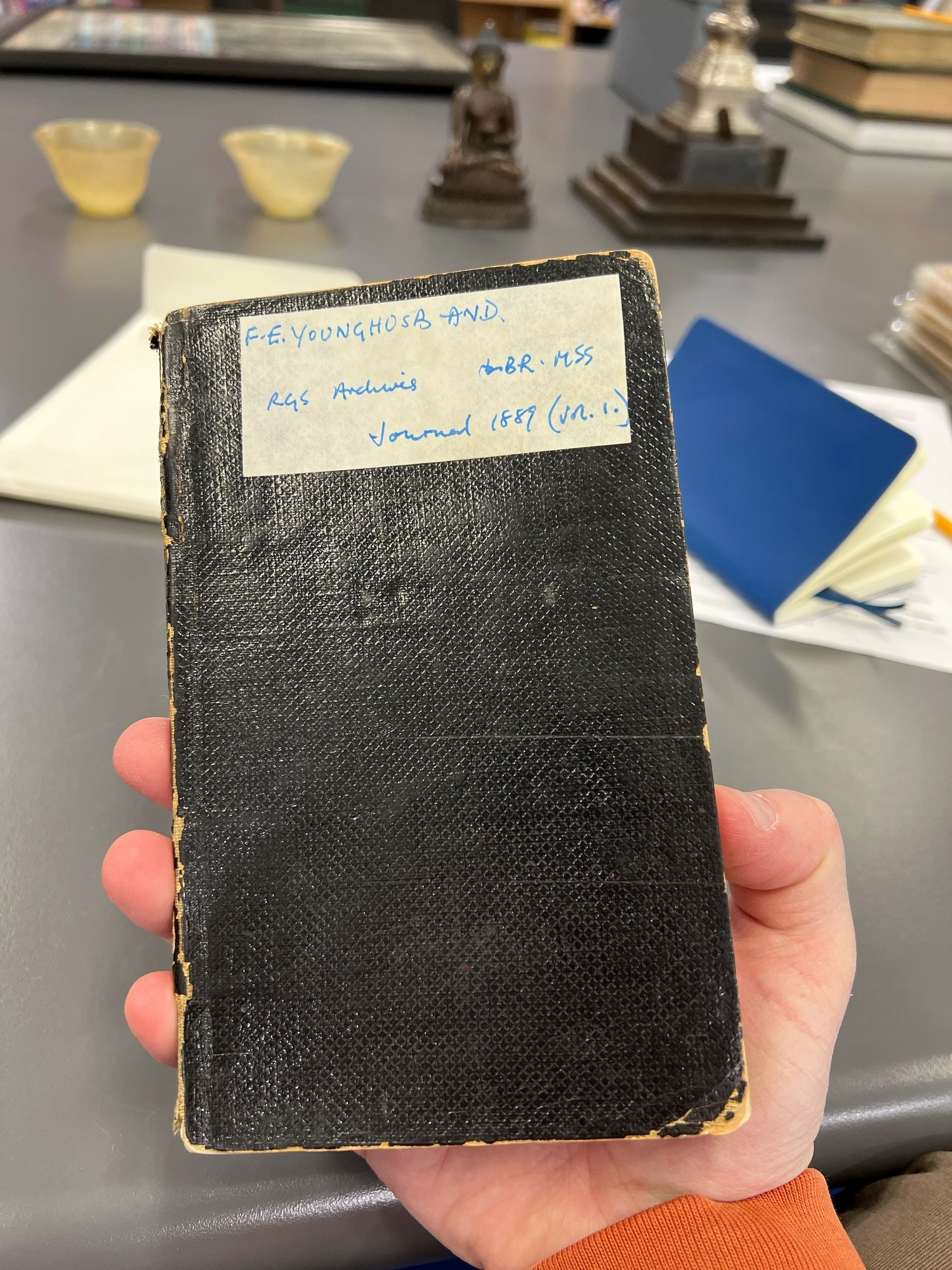Chad holds up a small pocket journal labelled FE YOUNGHUSBAND Journal 1889