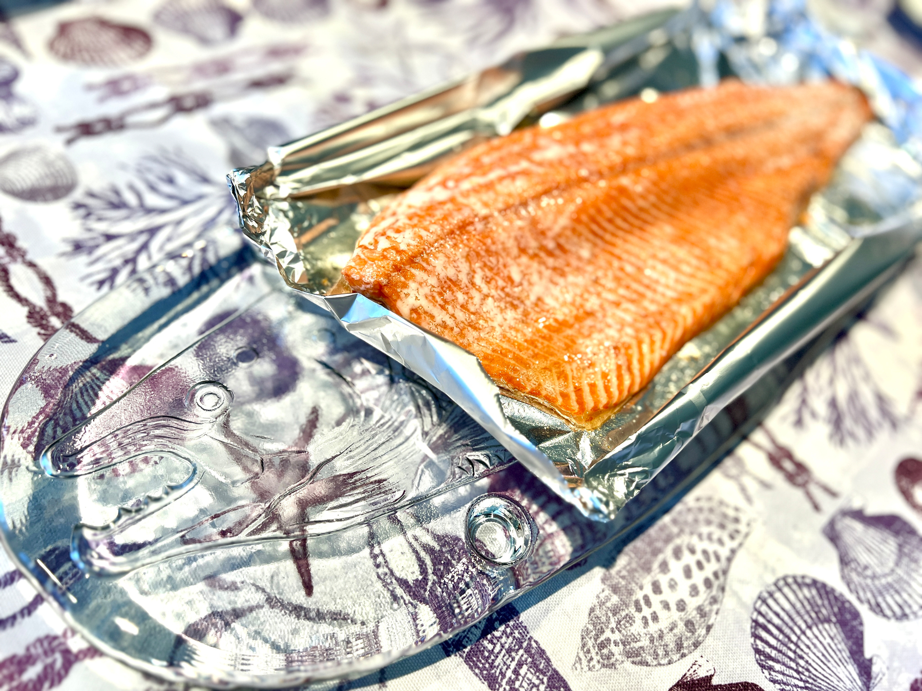 Baked salmon fillet on a glass plate with a salmon decoration