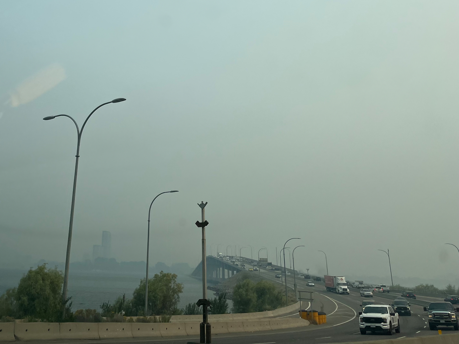 On the west side of WAC Bennet bridge. Across the way are some silhouettes of tall buildings. Everything else is hidden by smoke