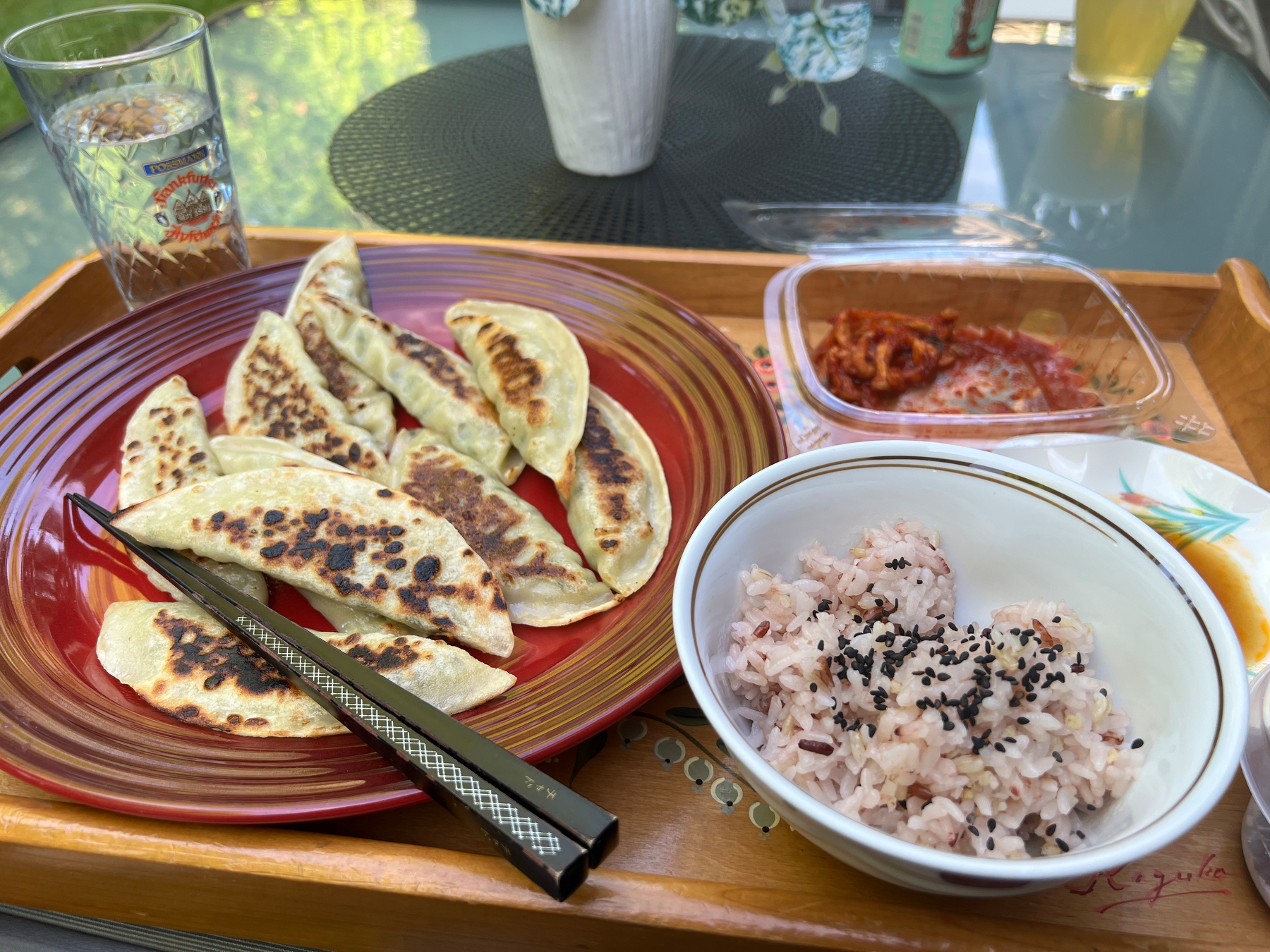 A bunch of fried Mandu on a plate, some kimchi daikon, and rice with black sesame and salt